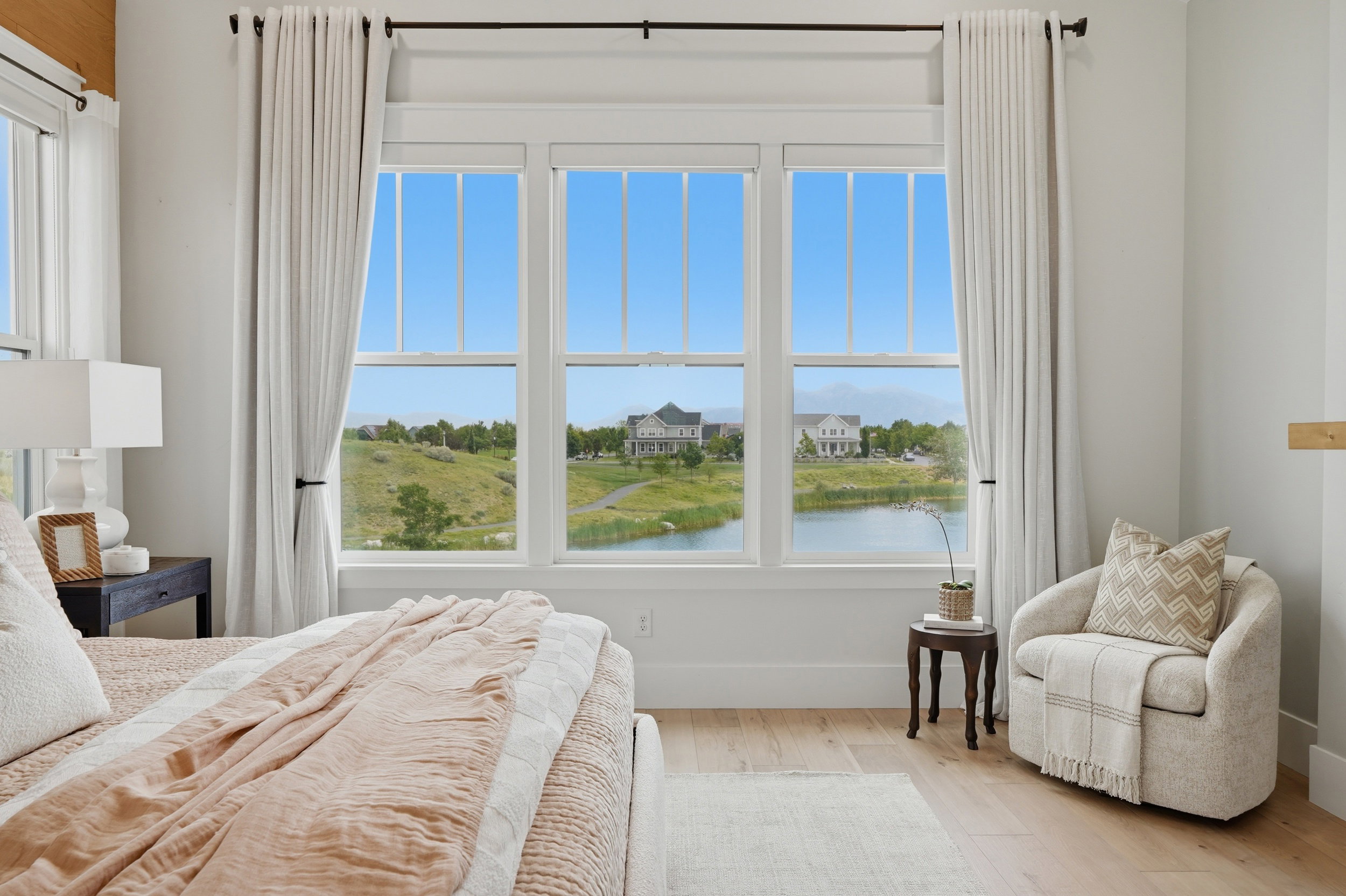 Expansive window wall overlooking a pond and distant landscape