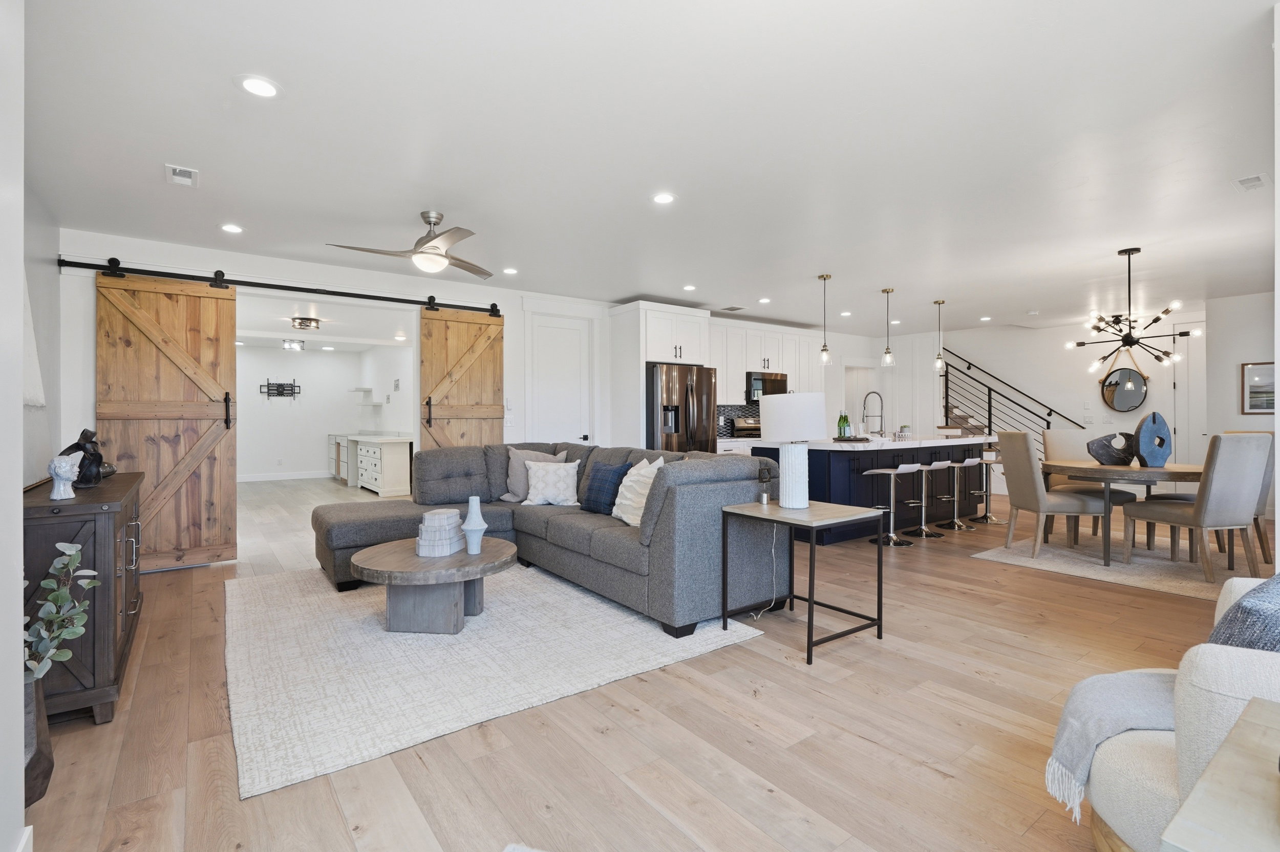 Open-concept living space featuring light wood-finish flooring, recessed lighting, and a ceiling fan