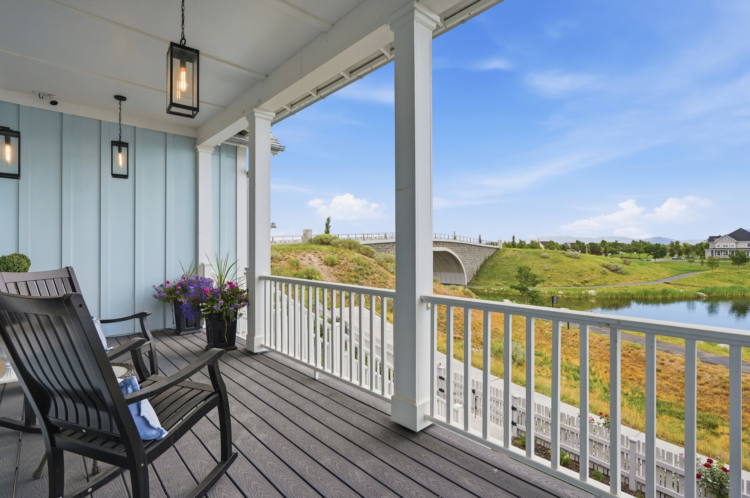 Covered outdoor living space featuring plank flooring and light blue board and batten siding