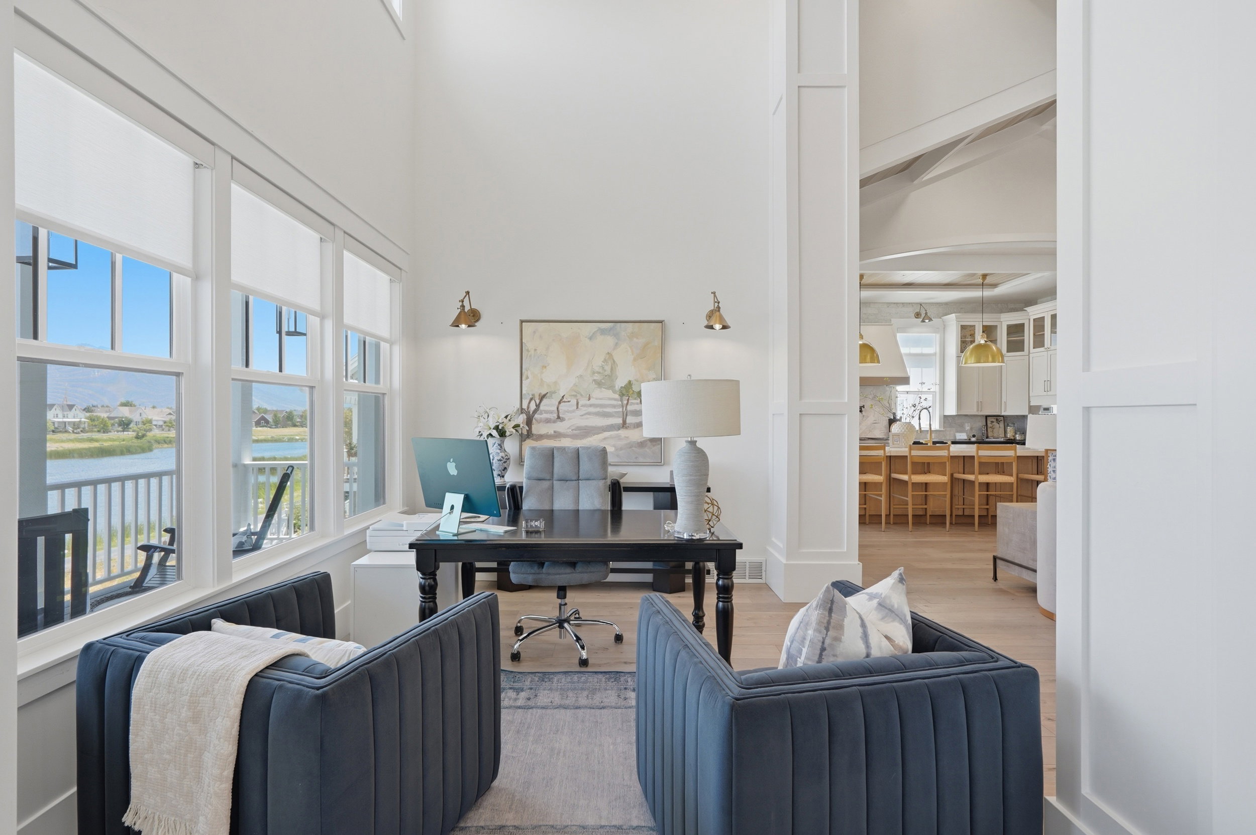 Bright room with multiple large windows overlooking a body of water