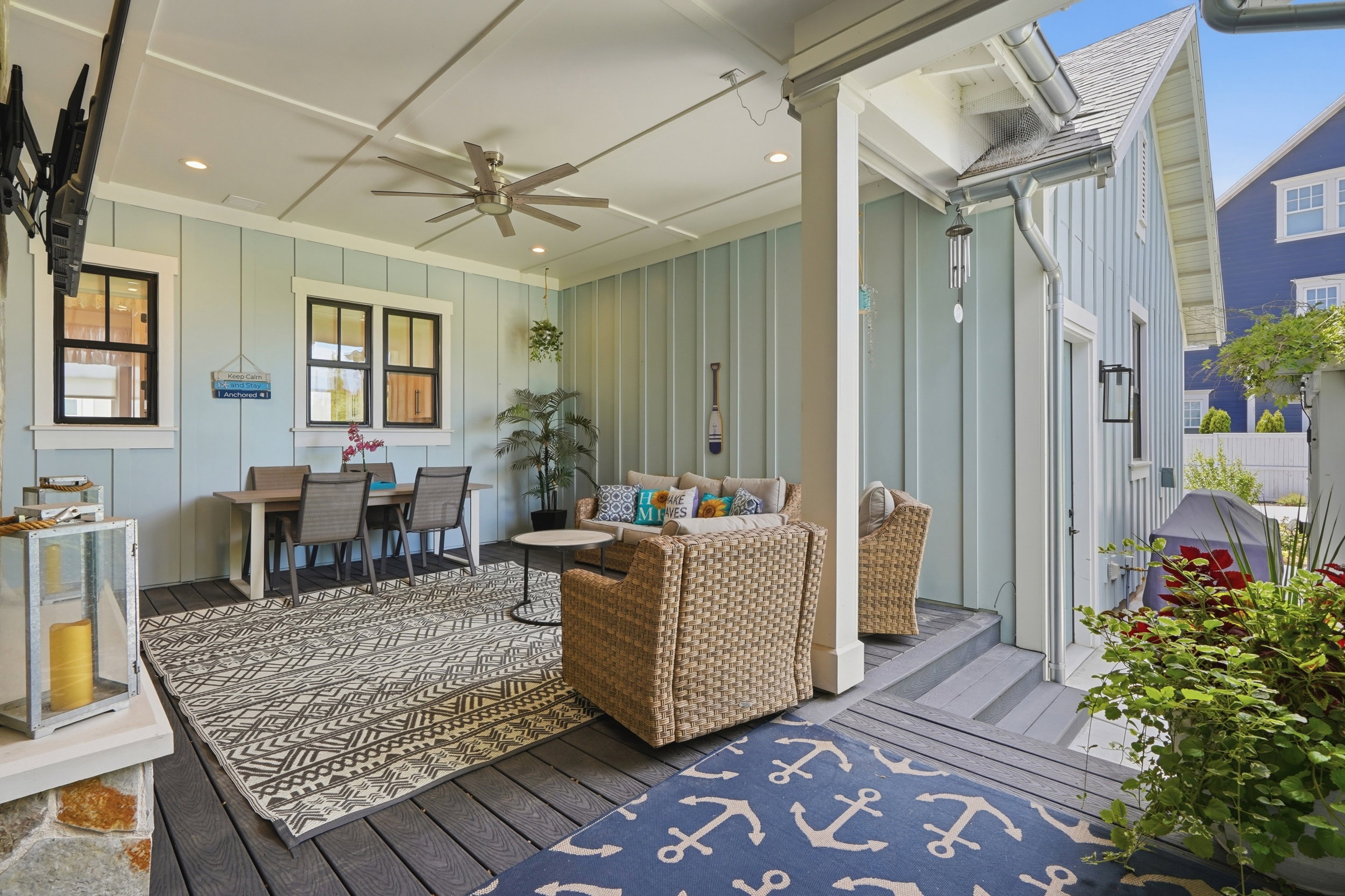 Expansive covered patio featuring board and batten siding, a coffered ceiling, and a ceiling fan
