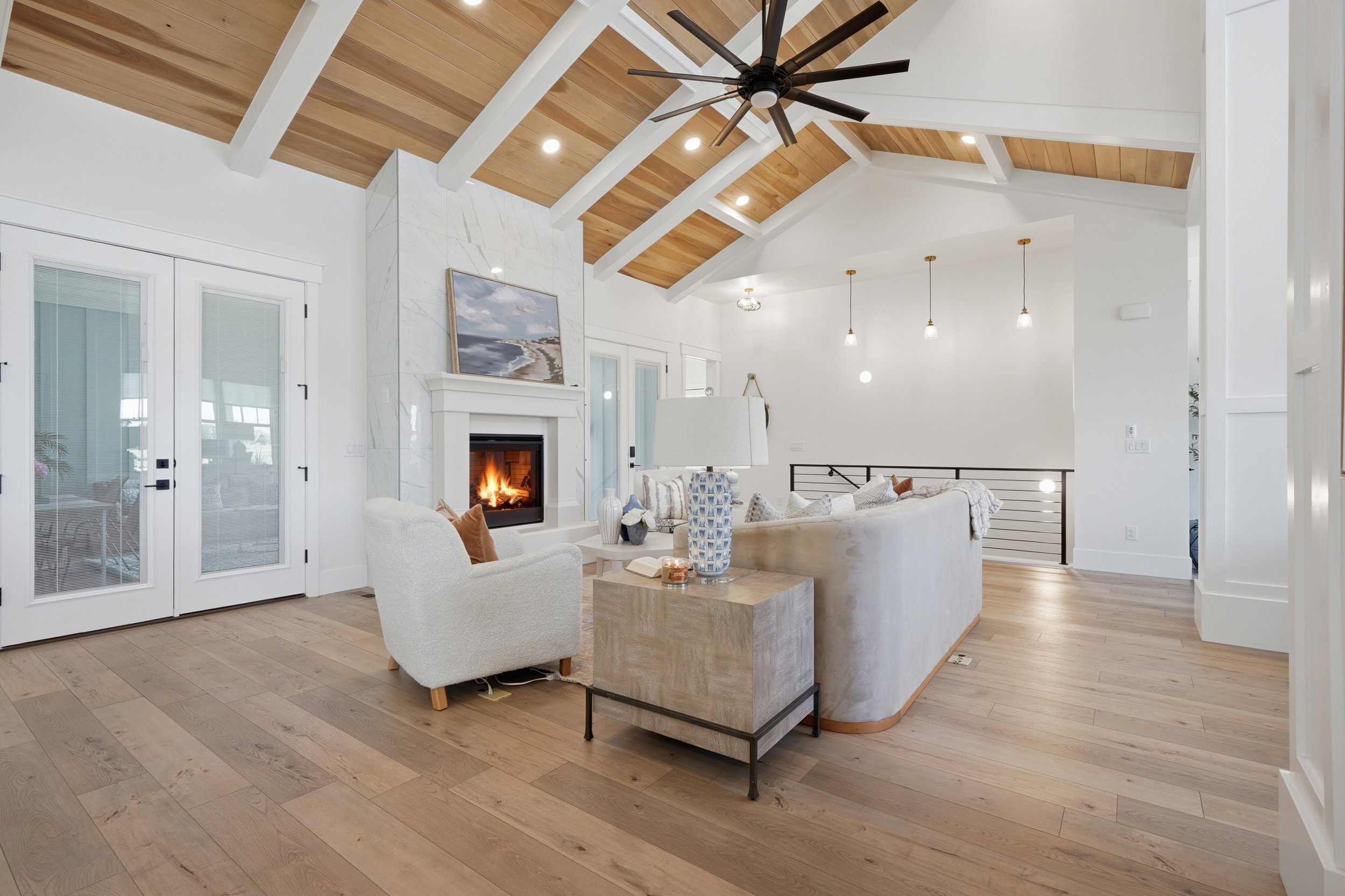 Vaulted wood-paneled ceiling with exposed white beams and recessed lighting