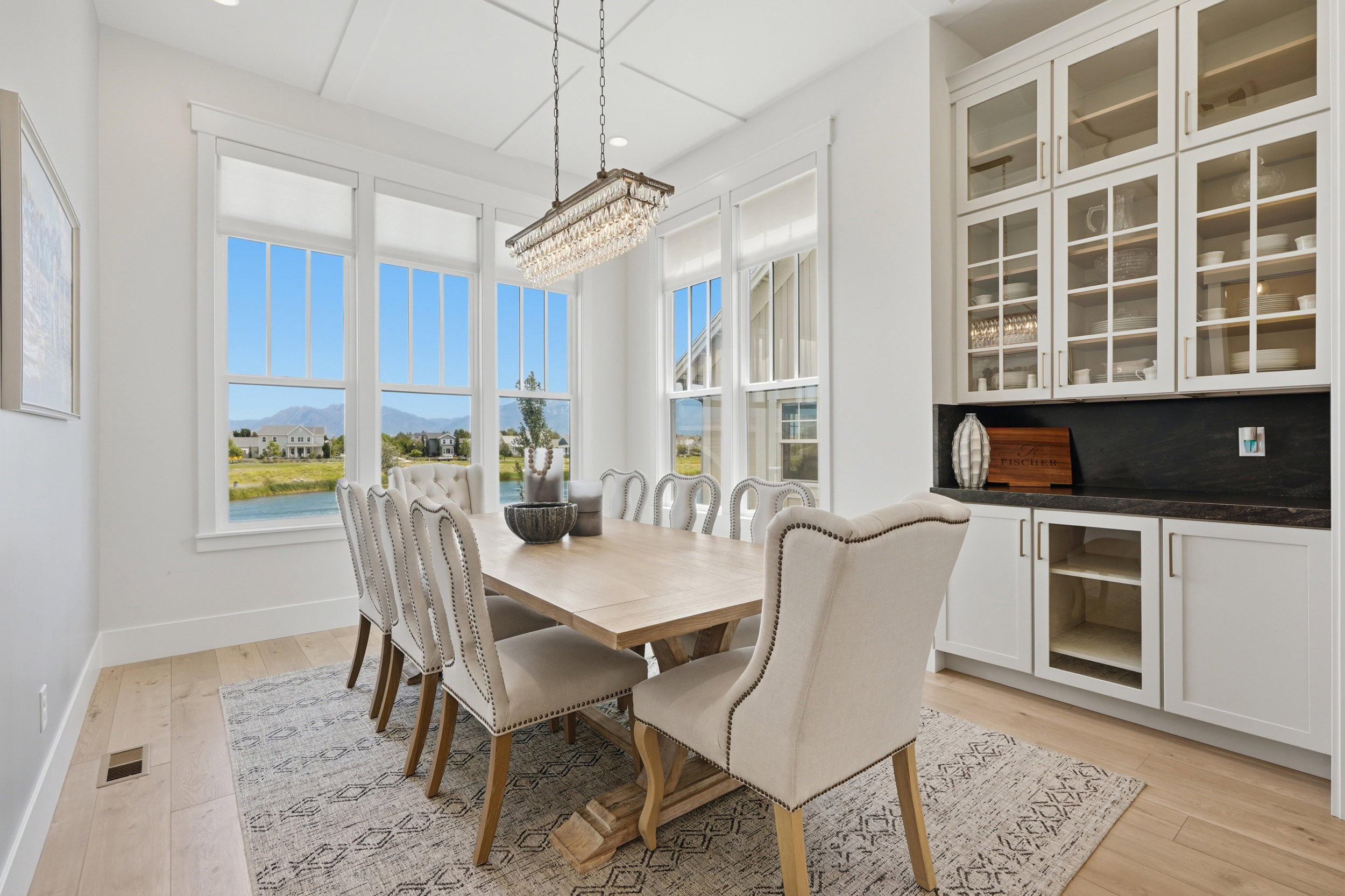 Dining area featuring a crystal chandelier, coffered ceiling, and light wood-finish flooring