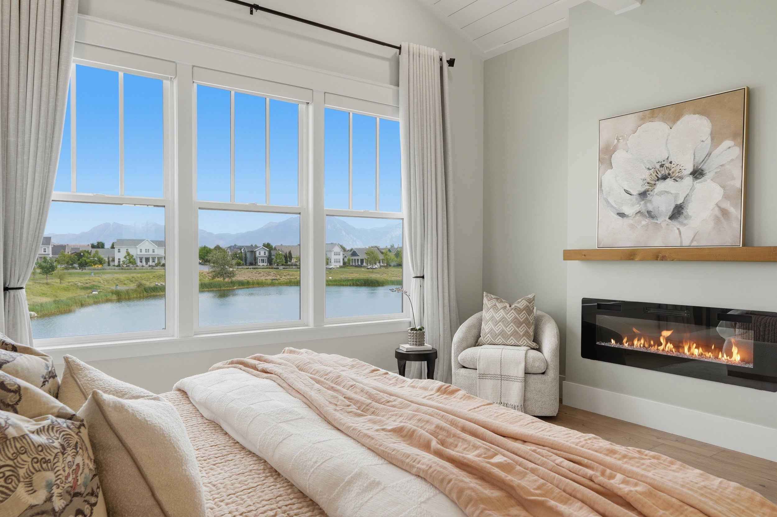 Expansive windows overlooking a tranquil lake and distant mountains