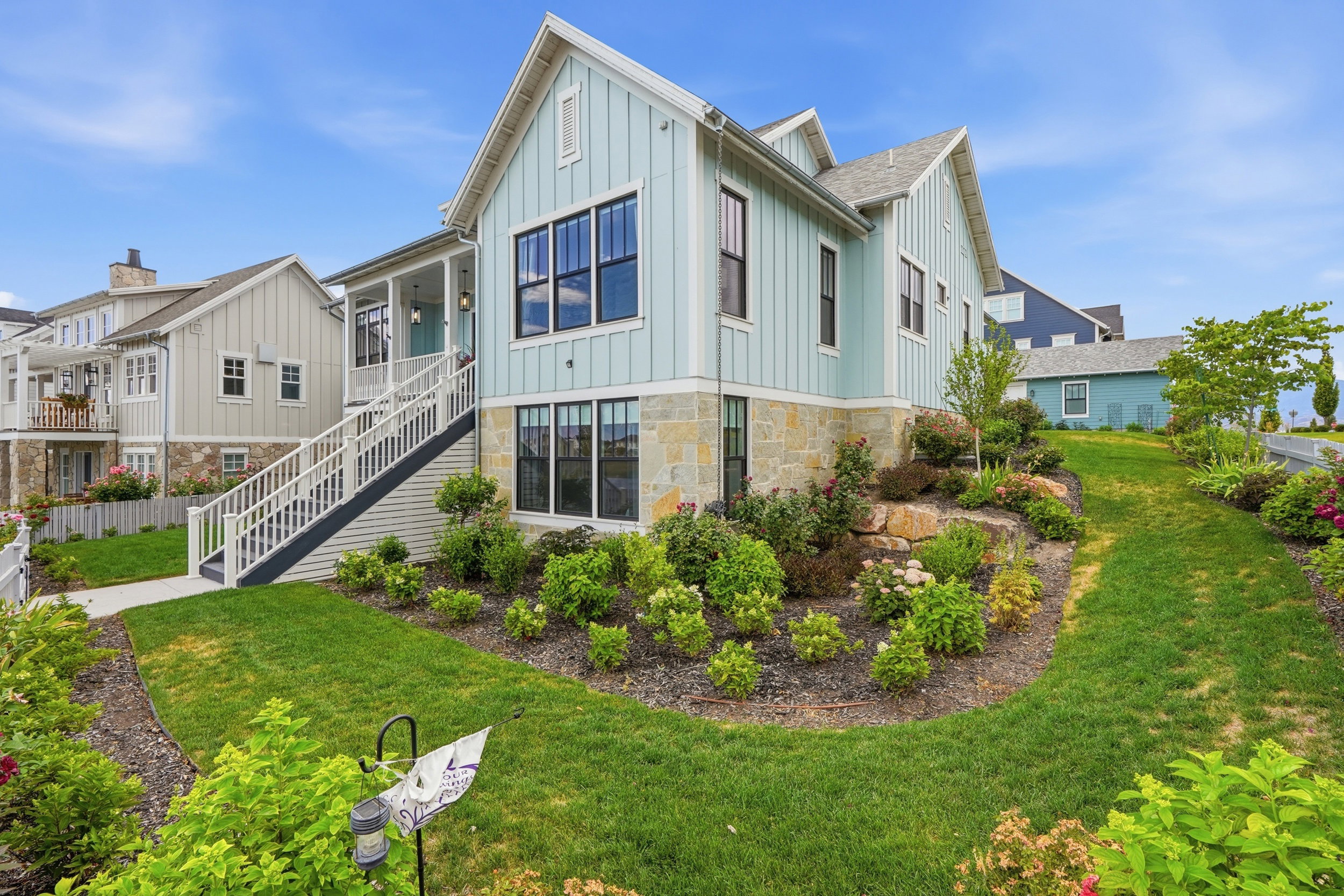 Light blue board and batten siding with stone foundation