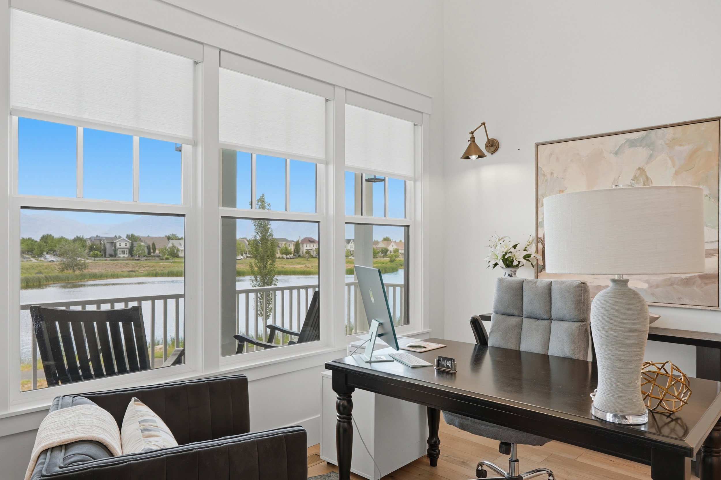 Room featuring hardwood-finish flooring, a wall-mounted sconce, and white walls
