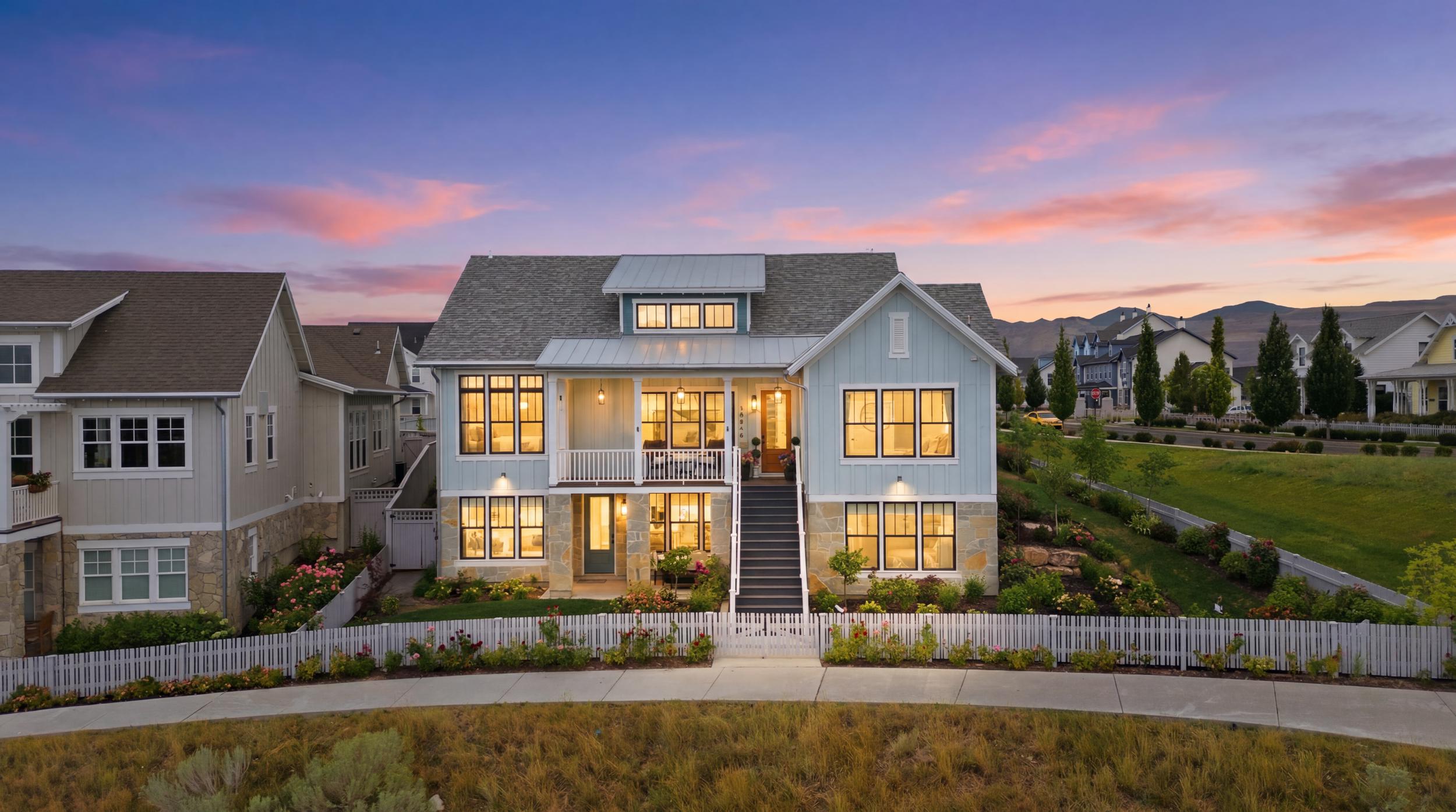 Light blue siding exterior with stone accents and a white picket fence