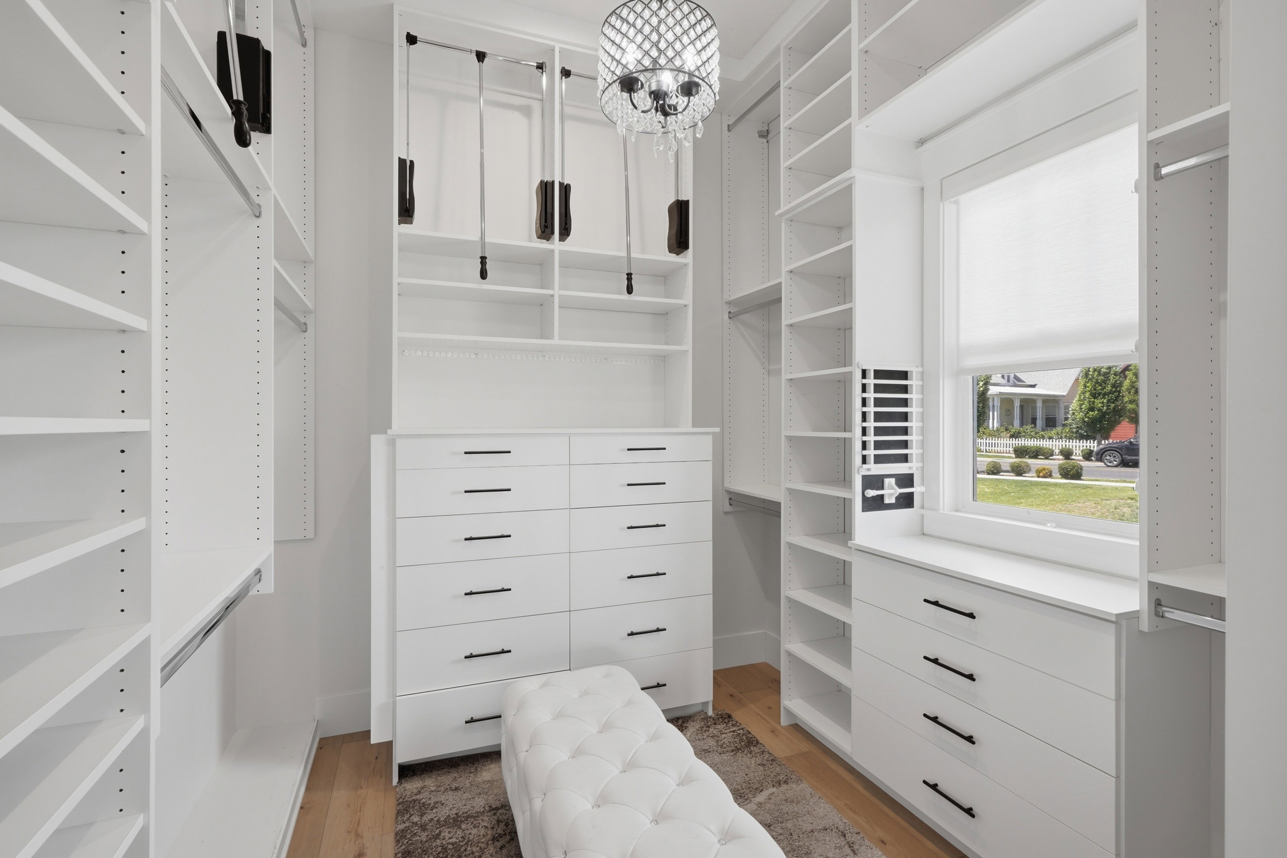Custom closet system featuring extensive shelving, built-in drawer units, and hanging rods