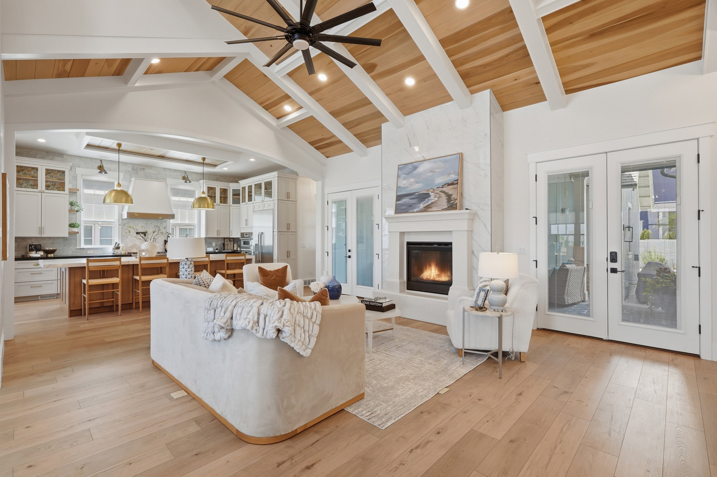 Vaulted ceiling with exposed wood-finish beams, recessed lighting, and a modern ceiling fan