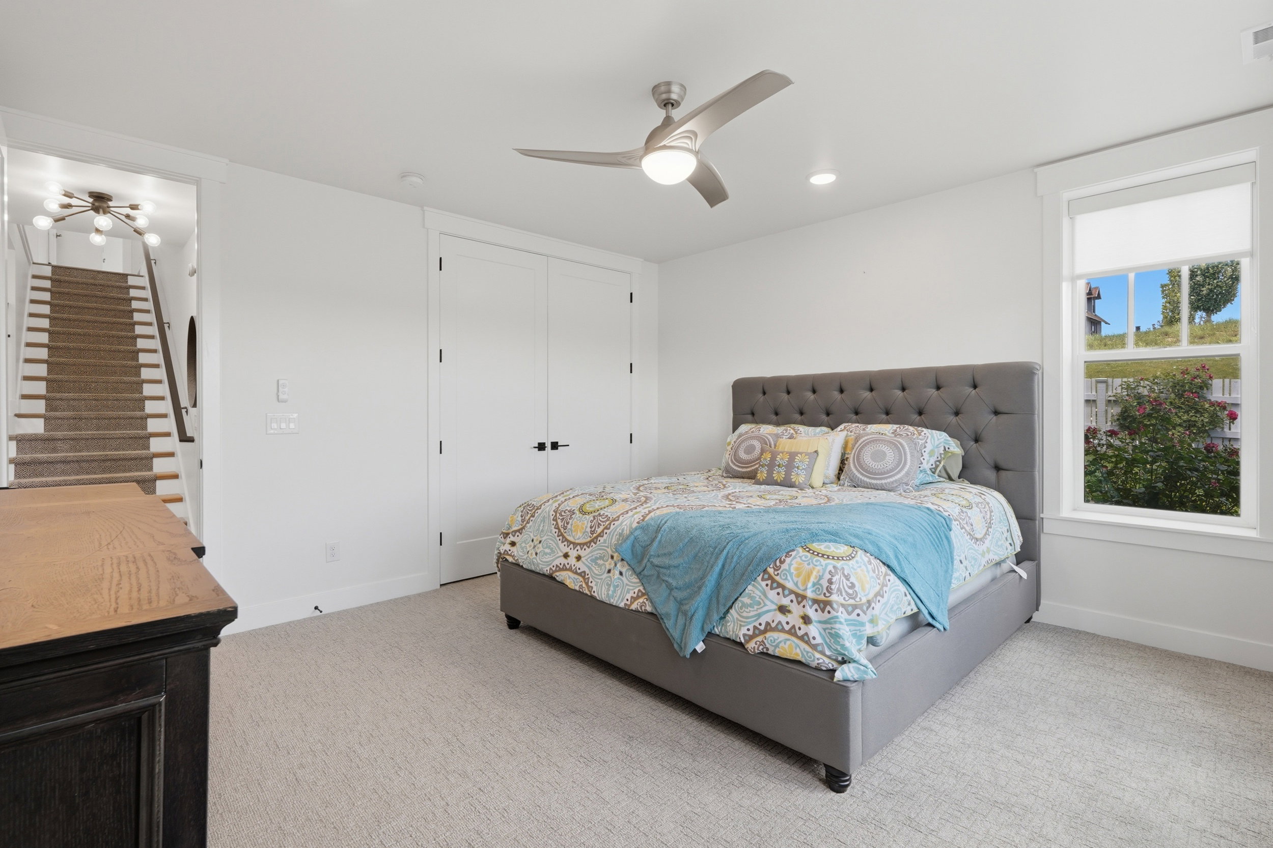 Carpeted room with white walls and a large window