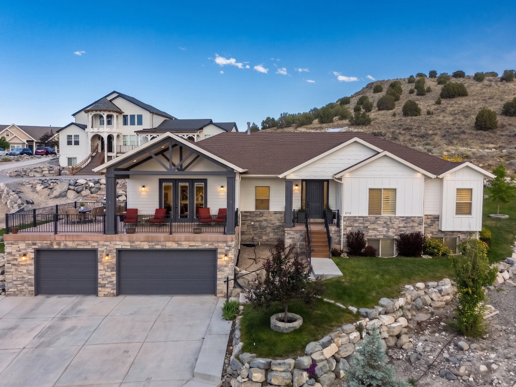 Contemporary home featuring white horizontal and vertical siding with stone accents