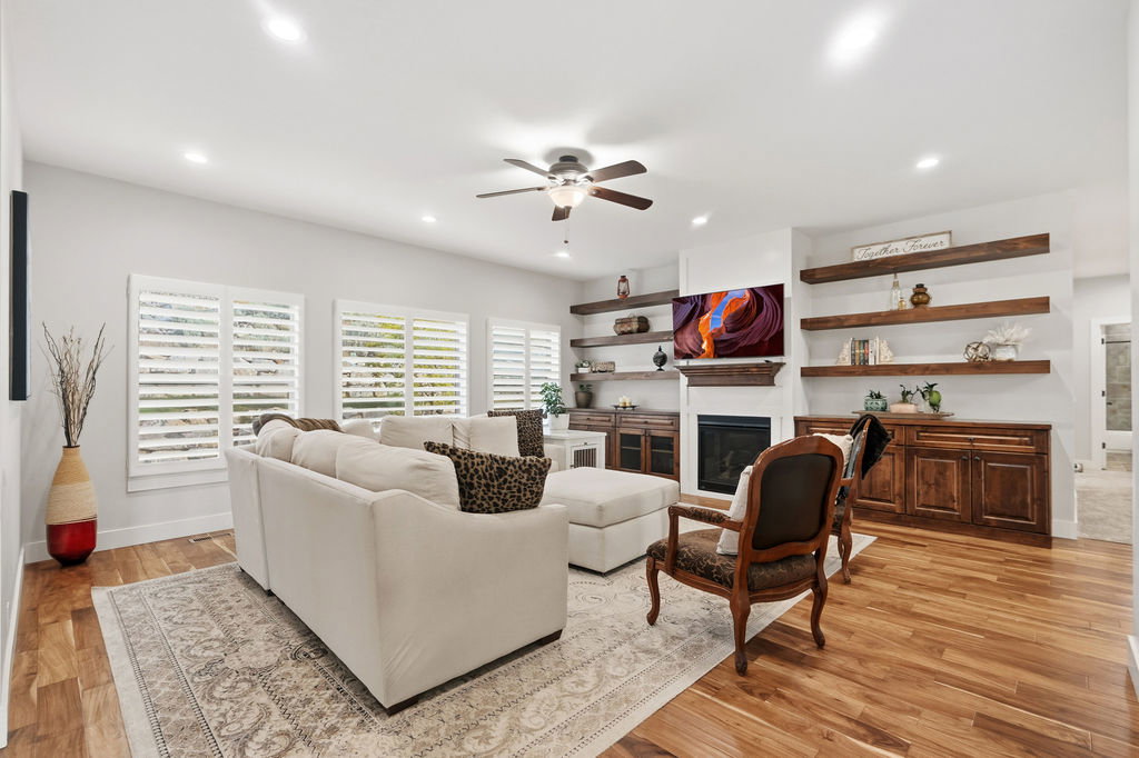 Living area featuring wood-finish flooring, recessed lighting, and a ceiling fan