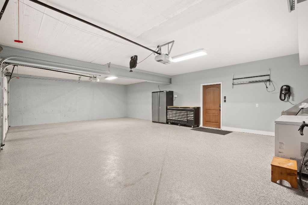 Spacious two-car garage featuring a speckled epoxy floor coating and light gray painted walls