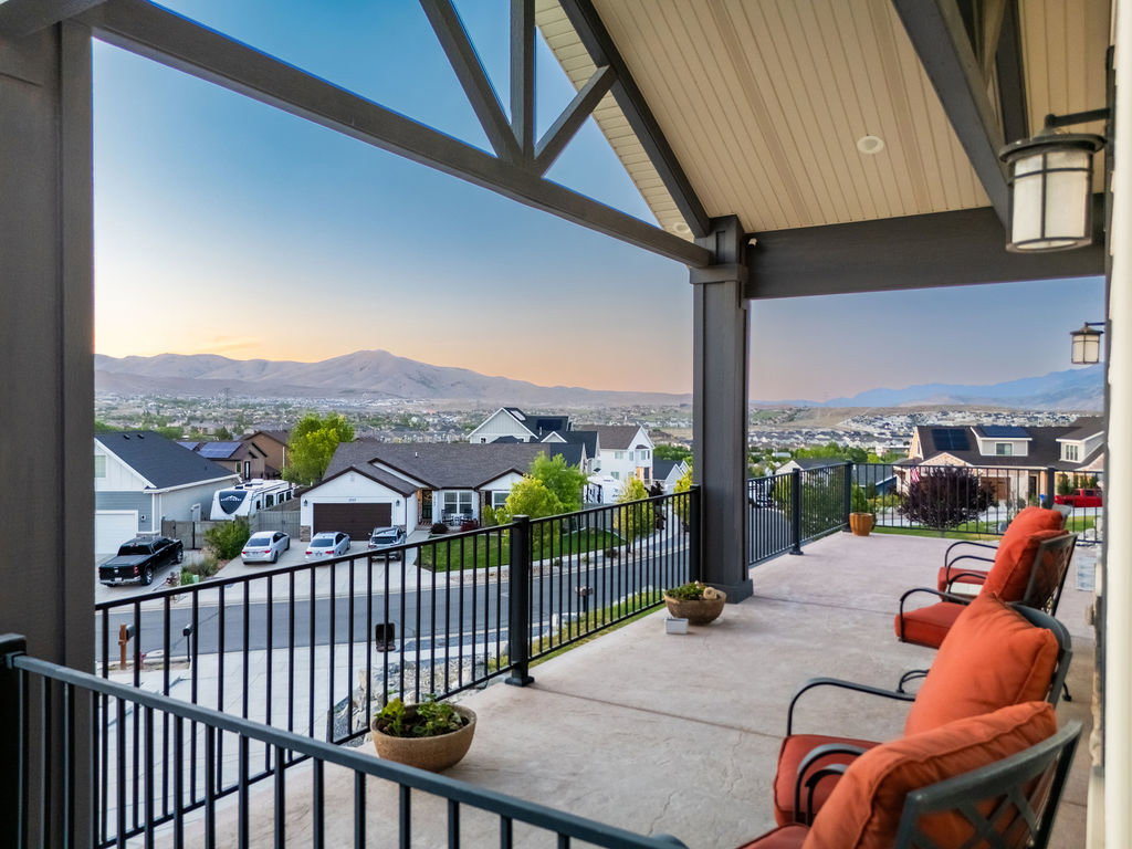 Spacious covered porch with a concrete surface and black metal railing