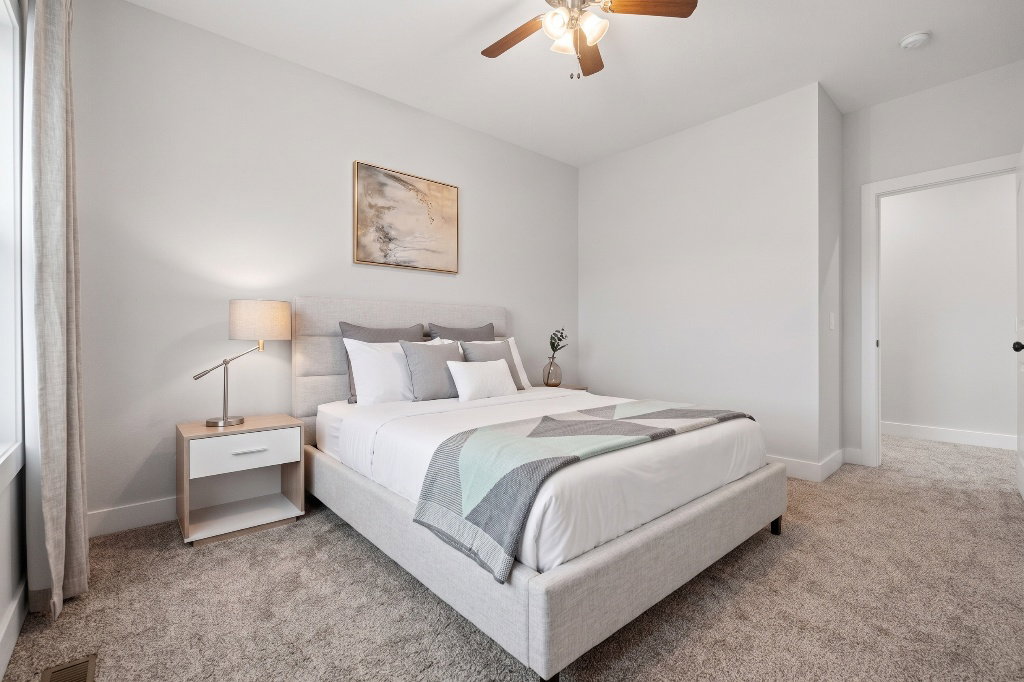 Carpeted room featuring a ceiling fan with integrated lighting, a window with vertical blinds, an open doorway, and a neutral color palette