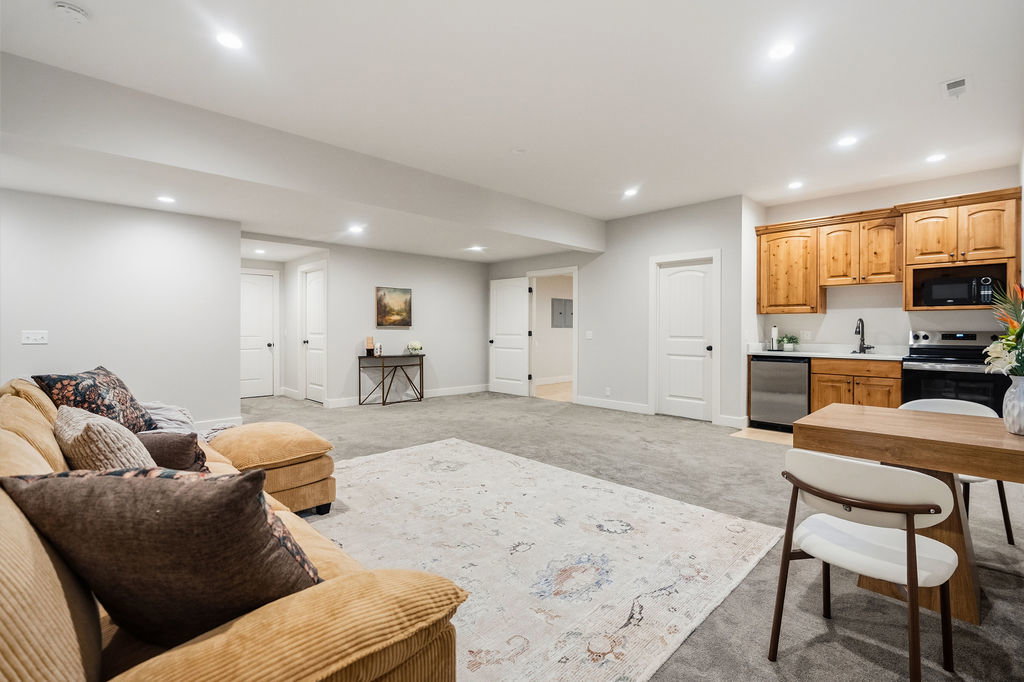 Spacious room featuring gray carpeting, recessed lighting, white walls, and multiple white paneled doors