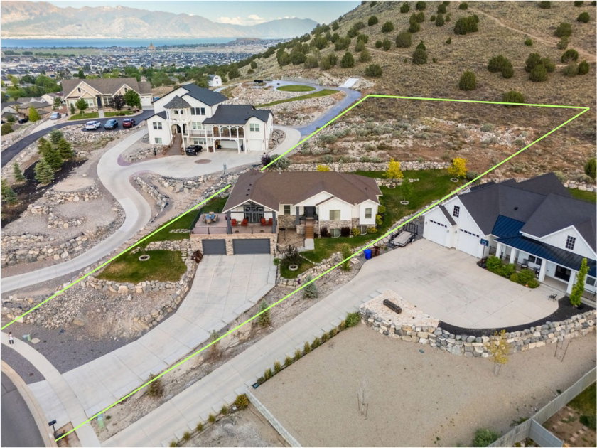 Upland lot featuring natural terrain, a distant body of water, and surrounding residential properties