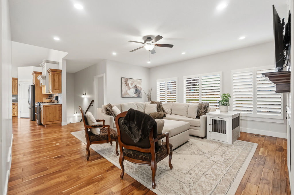 Spacious living area featuring wood-finish flooring, recessed lighting, and a ceiling fan