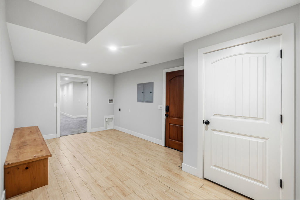 Neutral wall colors with recessed lighting and light wood-finish flooring