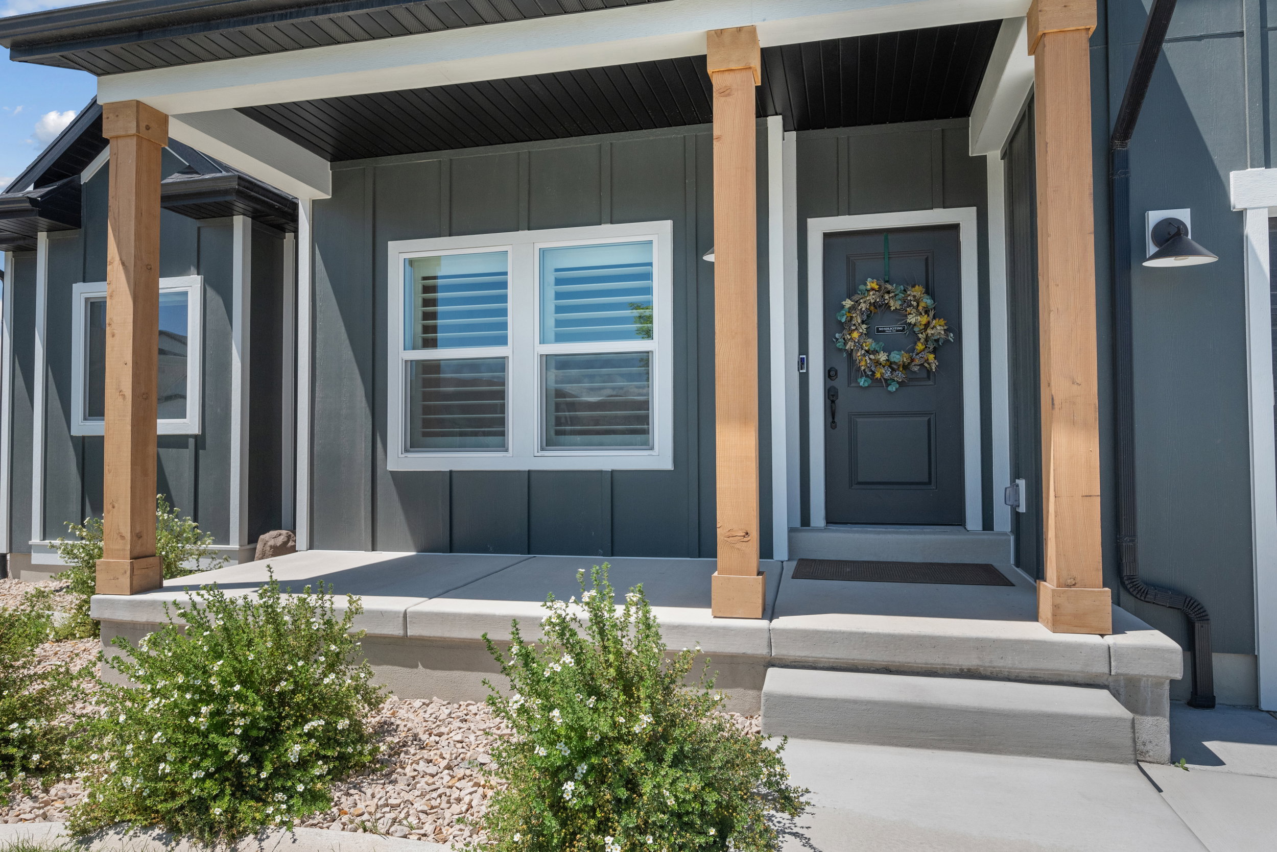 Modern gray exterior with natural wood-finish columns framing the entry