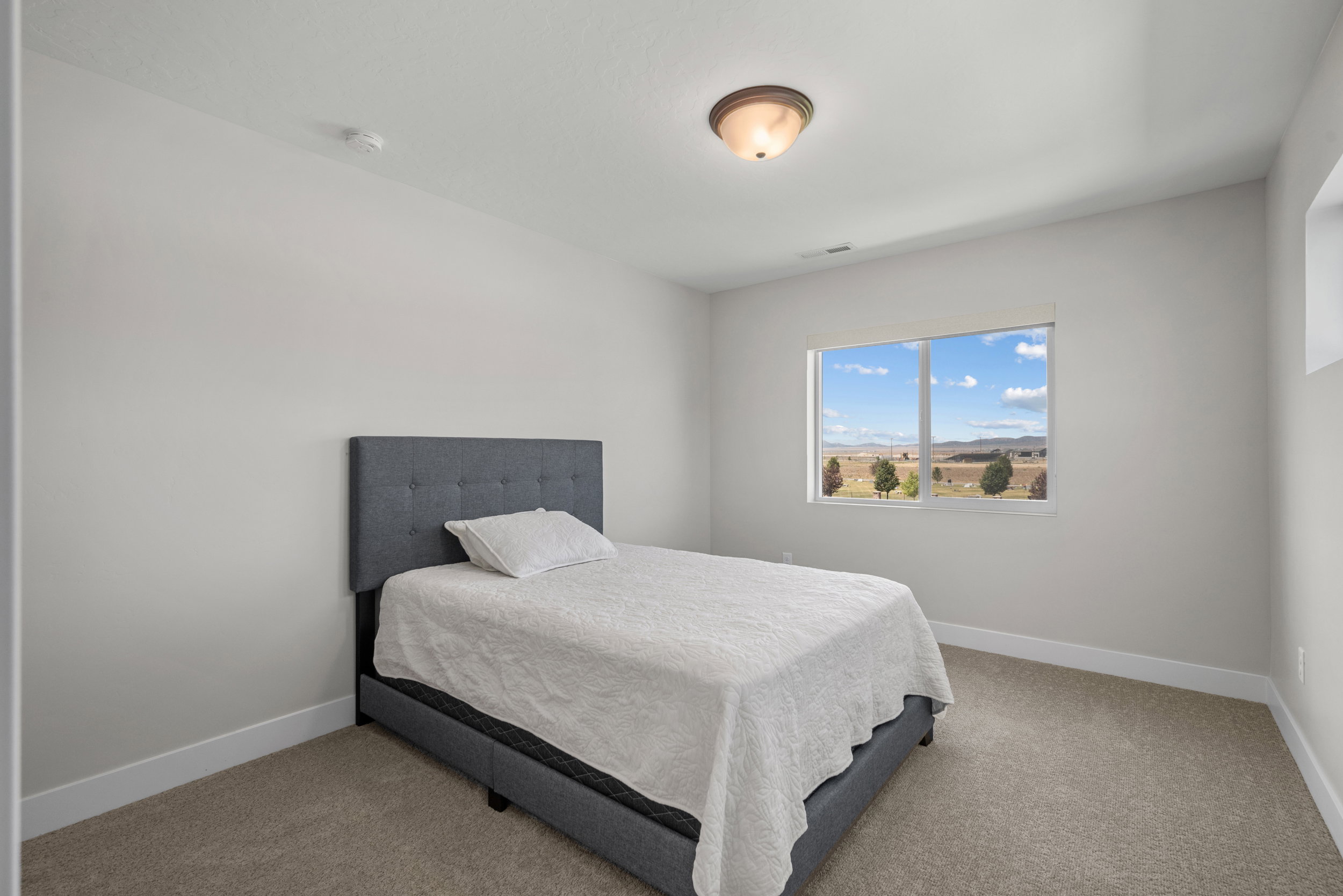 Neutral wall finishes complement the carpeted flooring