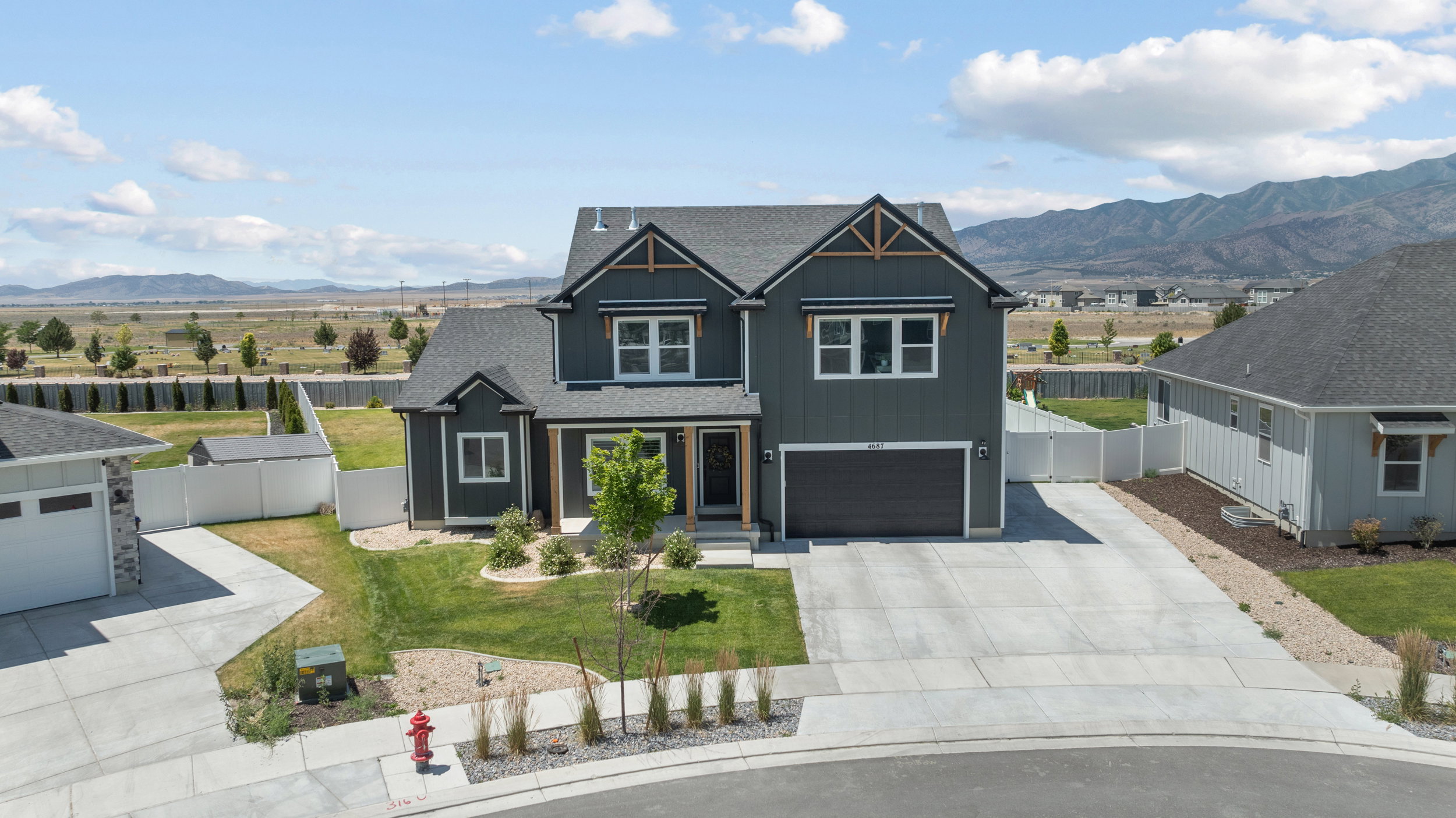 Modern two-story residence featuring dark siding with contrasting trim