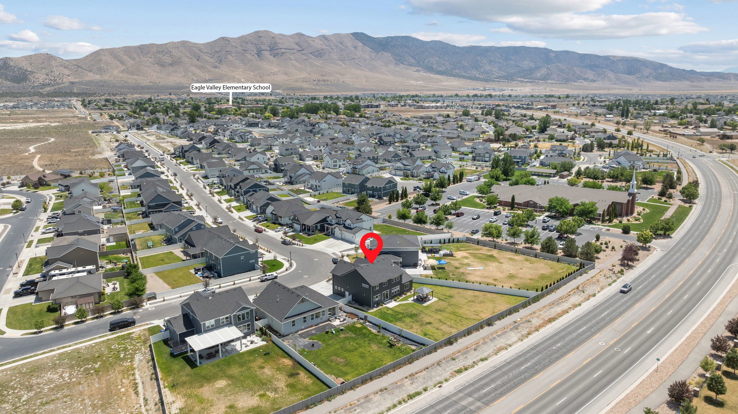 Aerial view of a residential community featuring single-family homes with gray roofing and varying exterior finishes