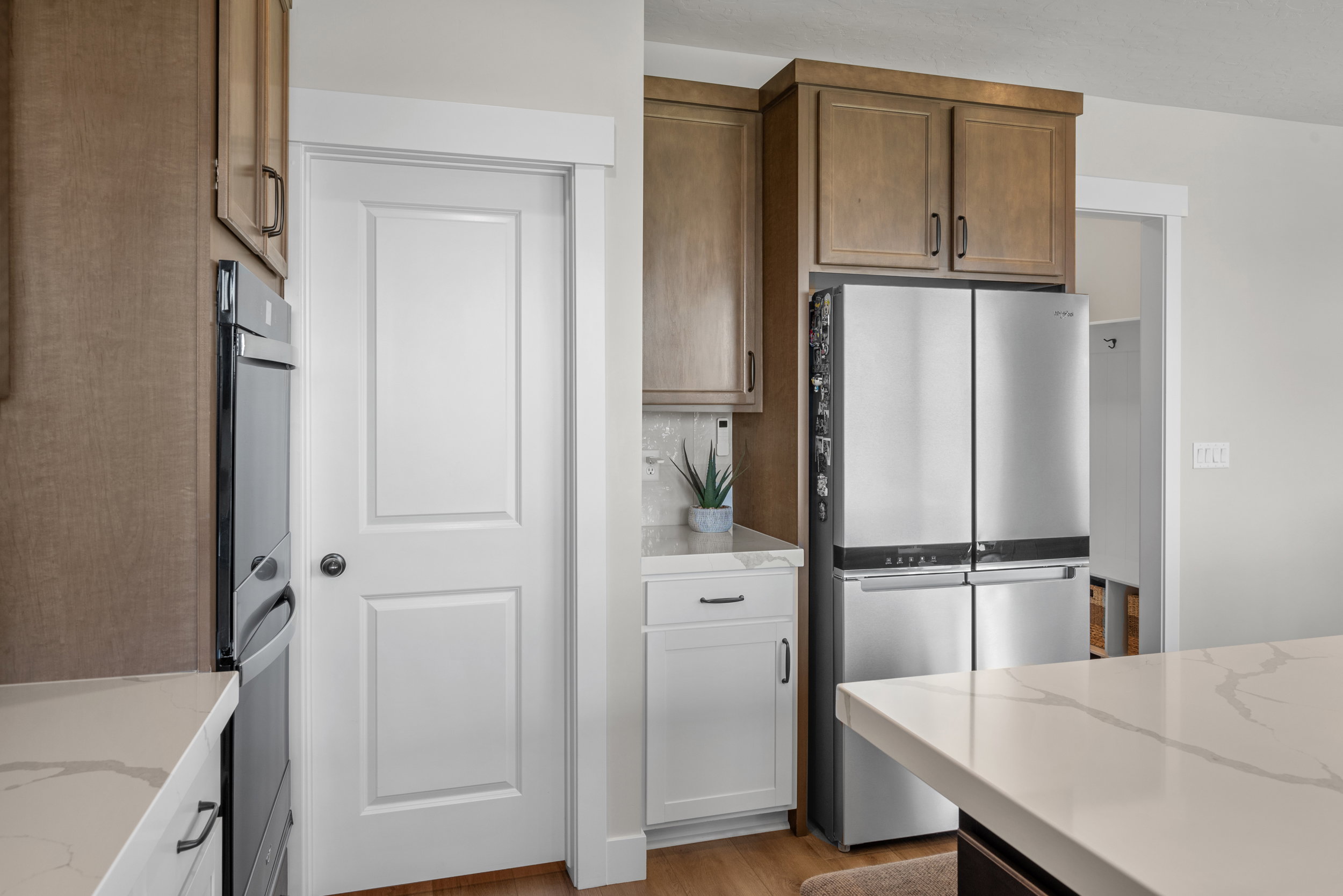 Kitchen featuring wood-finish cabinetry, stainless steel appliances, a built-in oven, and white countertops