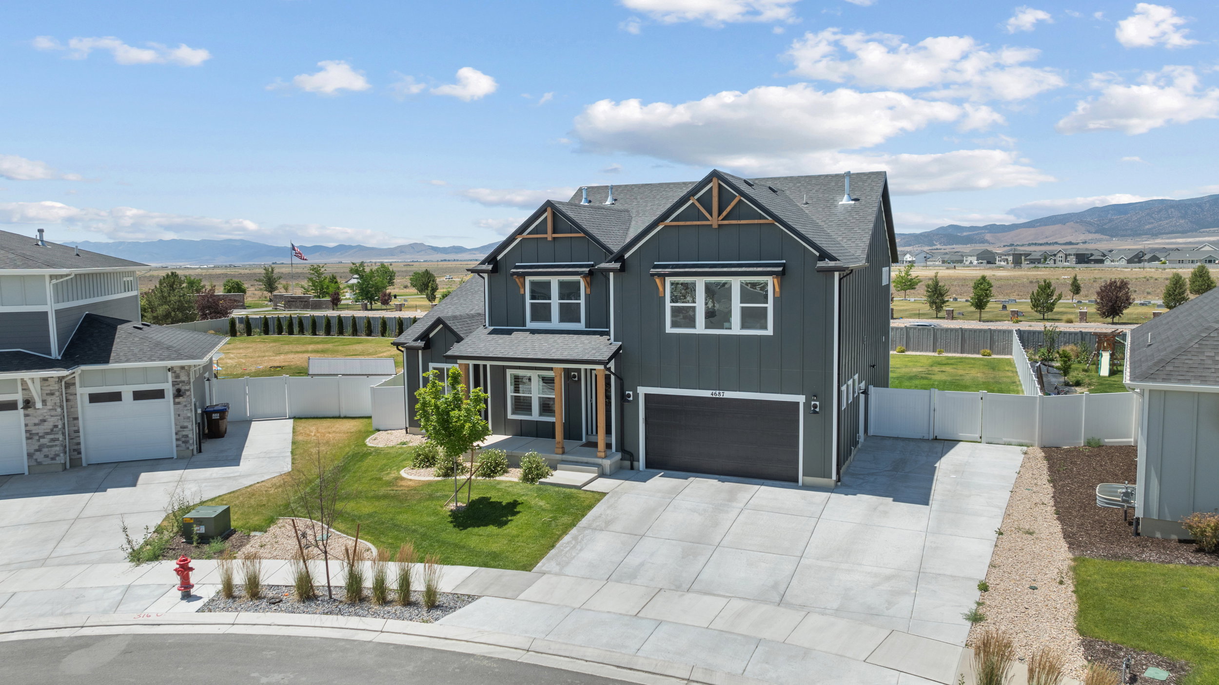 Contemporary two-story residence with a dark gray exterior and contrasting white trim