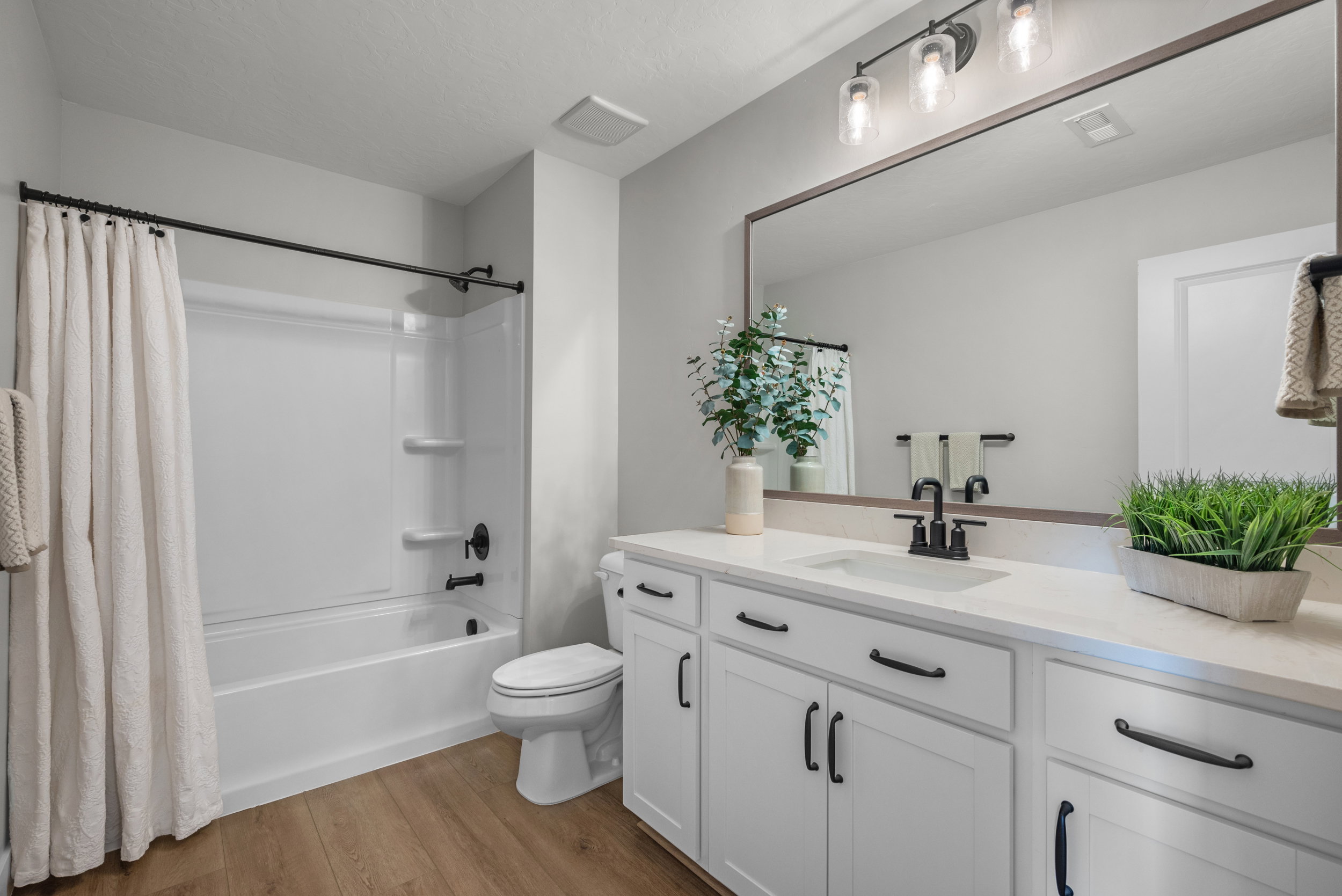 Bathroom featuring a white vanity with extensive counter space and black hardware