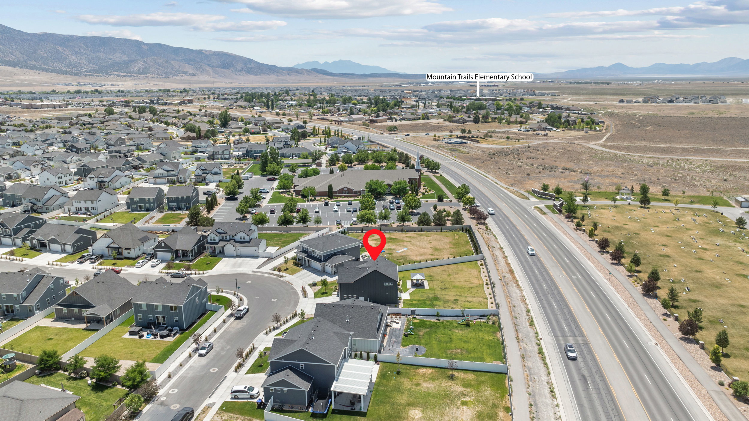 New construction residential development featuring a mountain backdrop and highway access