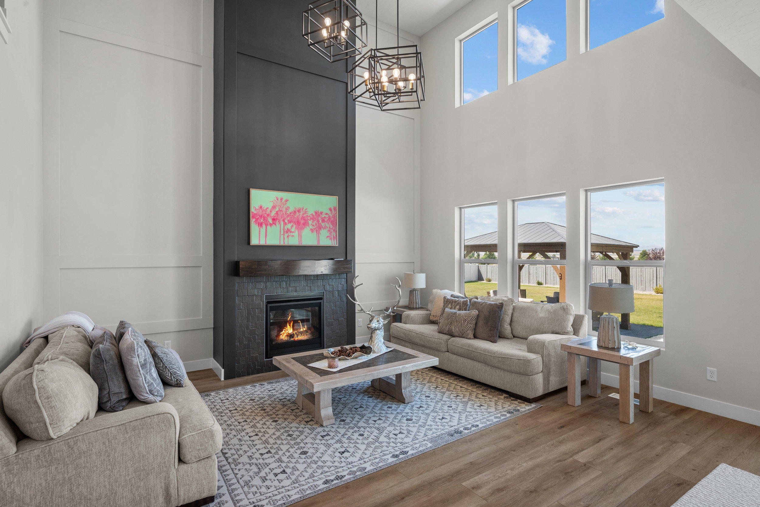 Two-story living area featuring a floor-to-ceiling fireplace with stone surround and wood mantel