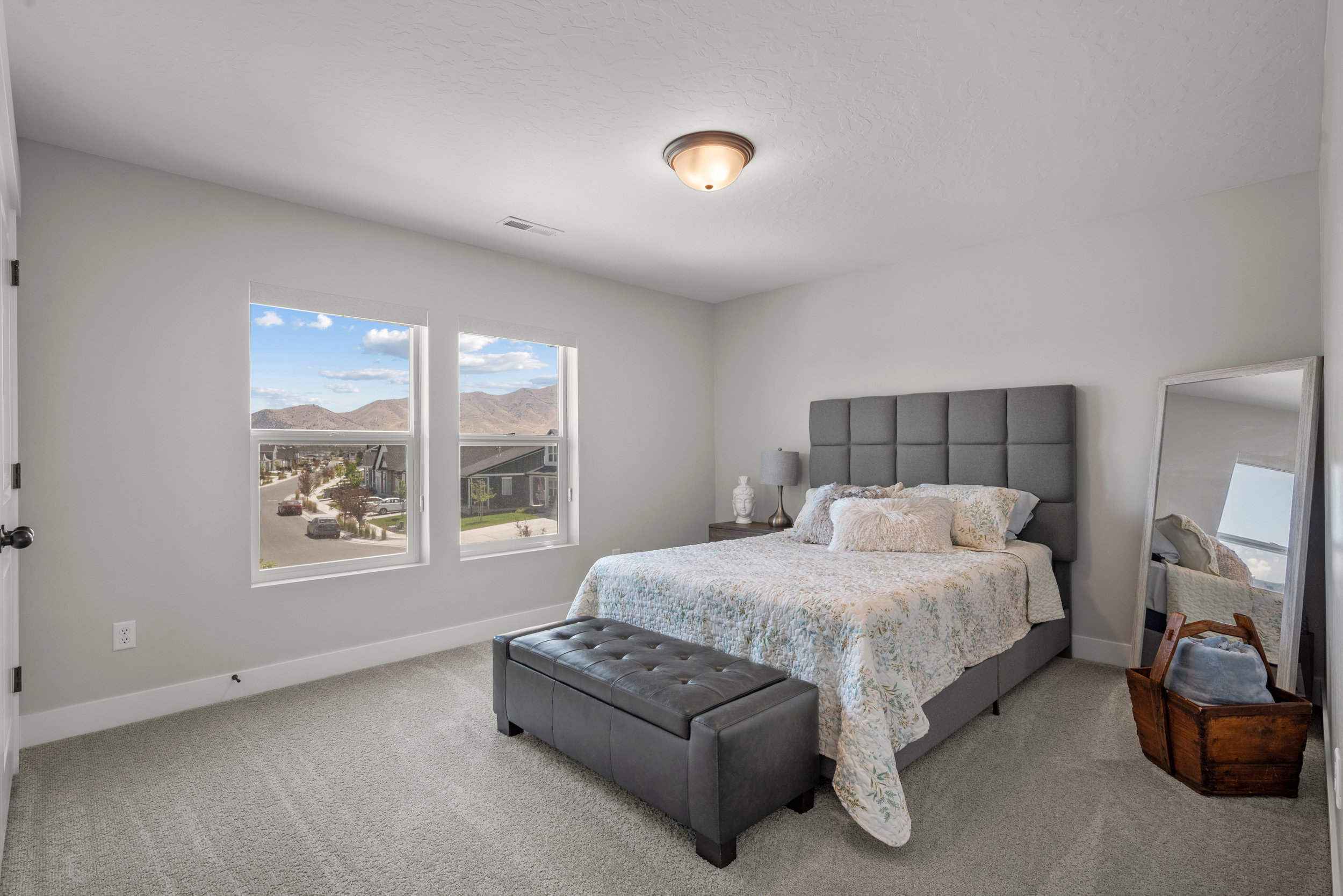 Spacious room featuring dual windows, gray wall-to-wall carpeting, and a flush-mount ceiling light fixture