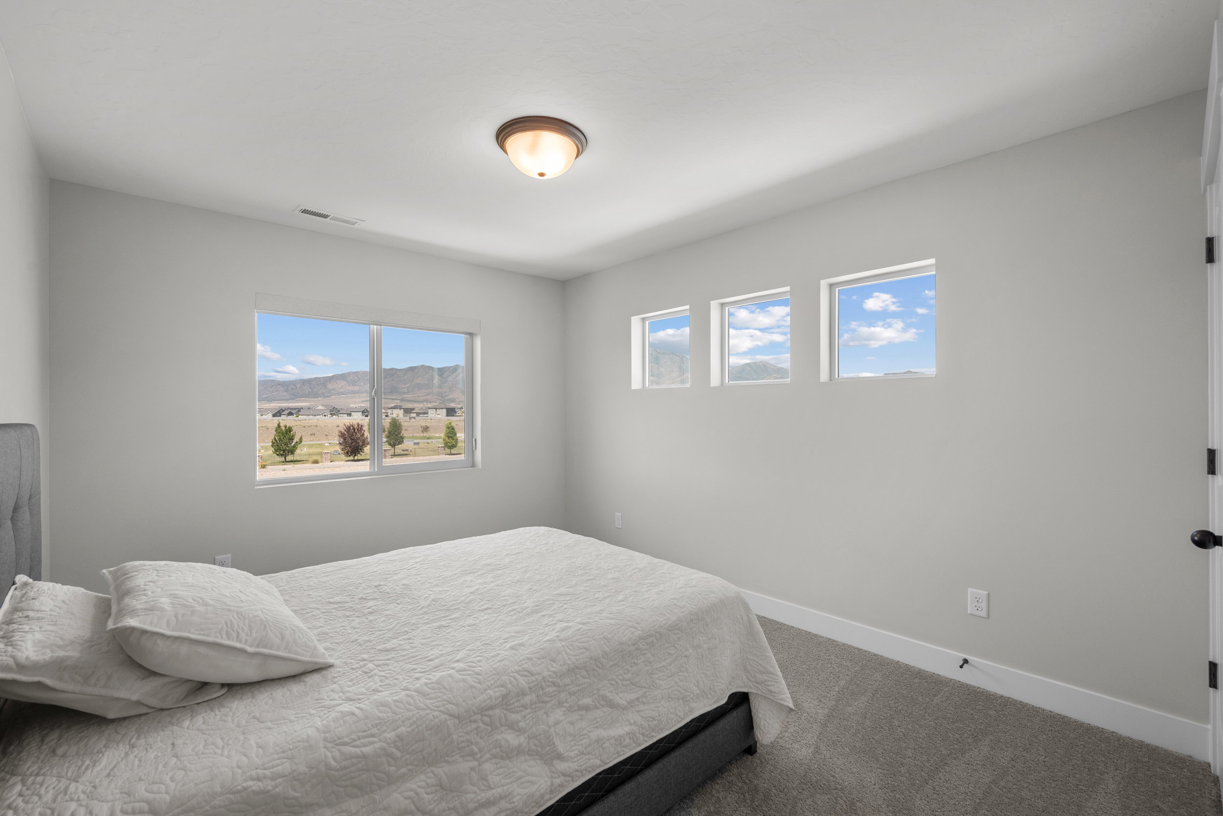 Room featuring a large picture window, three transom windows, and wall-to-wall carpeting