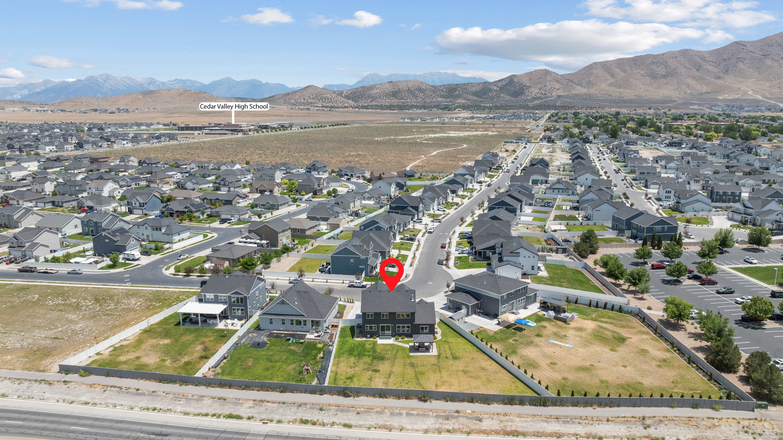 Expansive aerial view showcasing a residential neighborhood with mountain backdrops