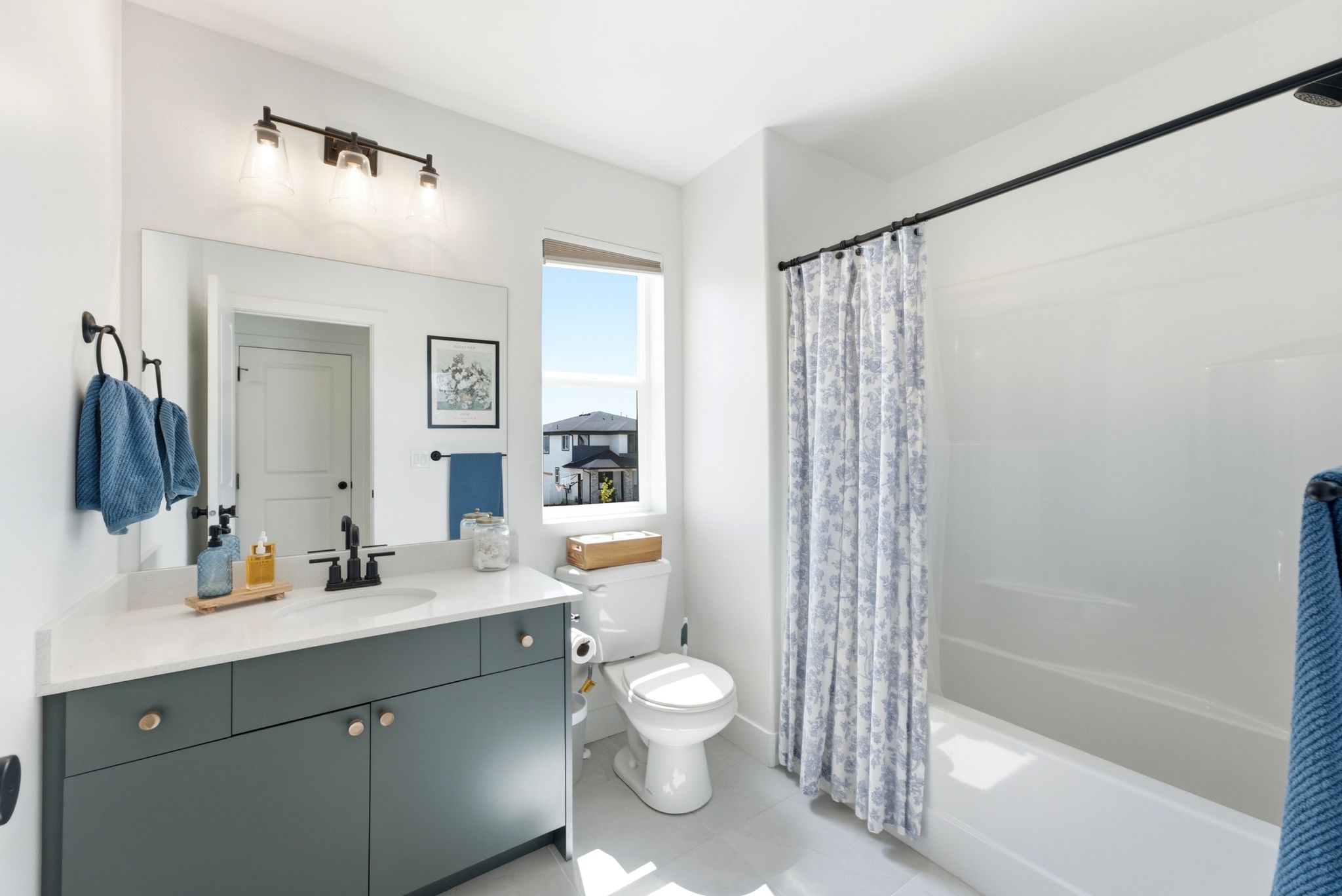 Bathroom featuring a full vanity with dark cabinetry, white countertop, and single basin sink with a matte black faucet