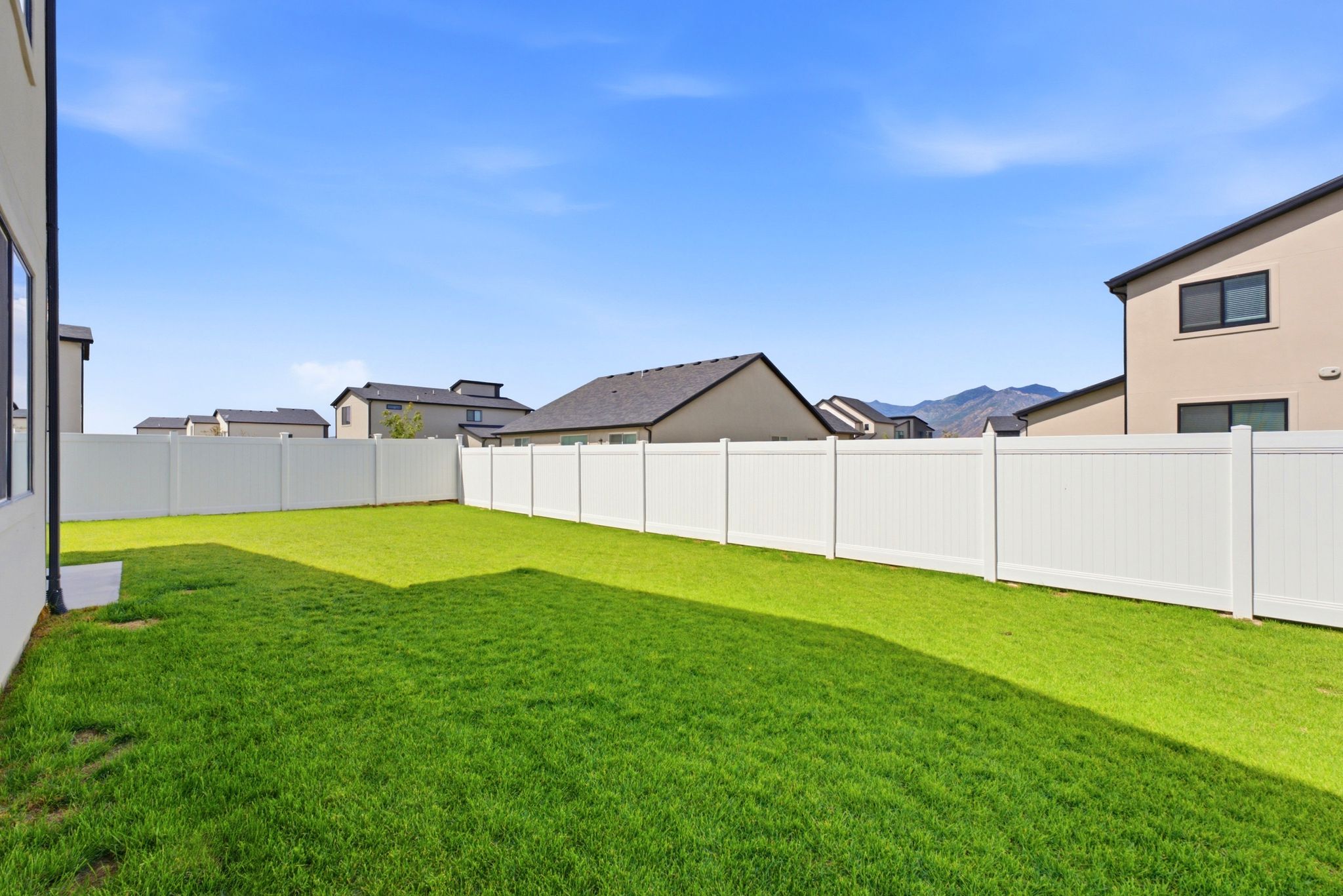 Spacious backyard featuring a manicured lawn and a full privacy fence