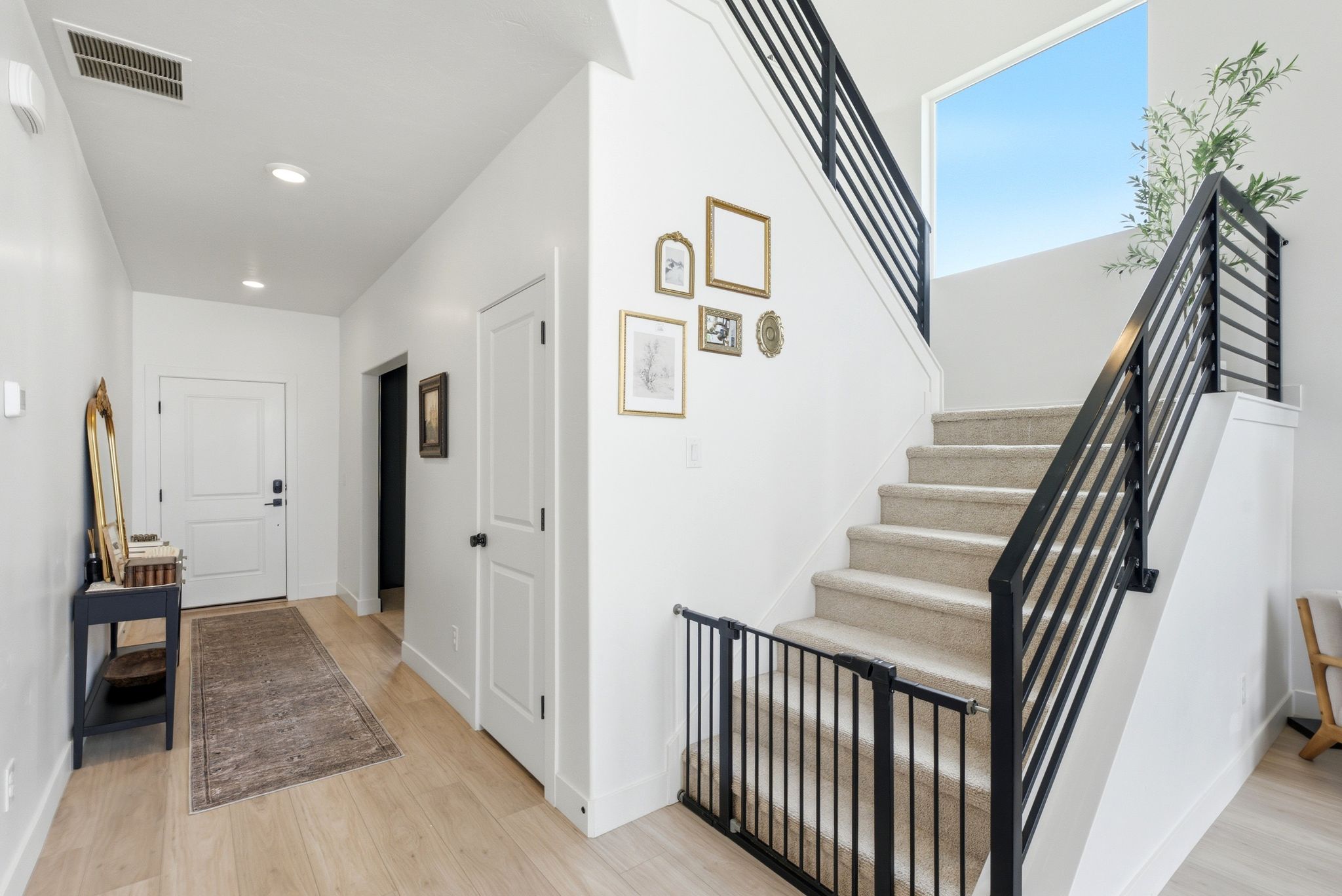 Entryway featuring wood-finish flooring, a white paneled door, and recessed lighting
