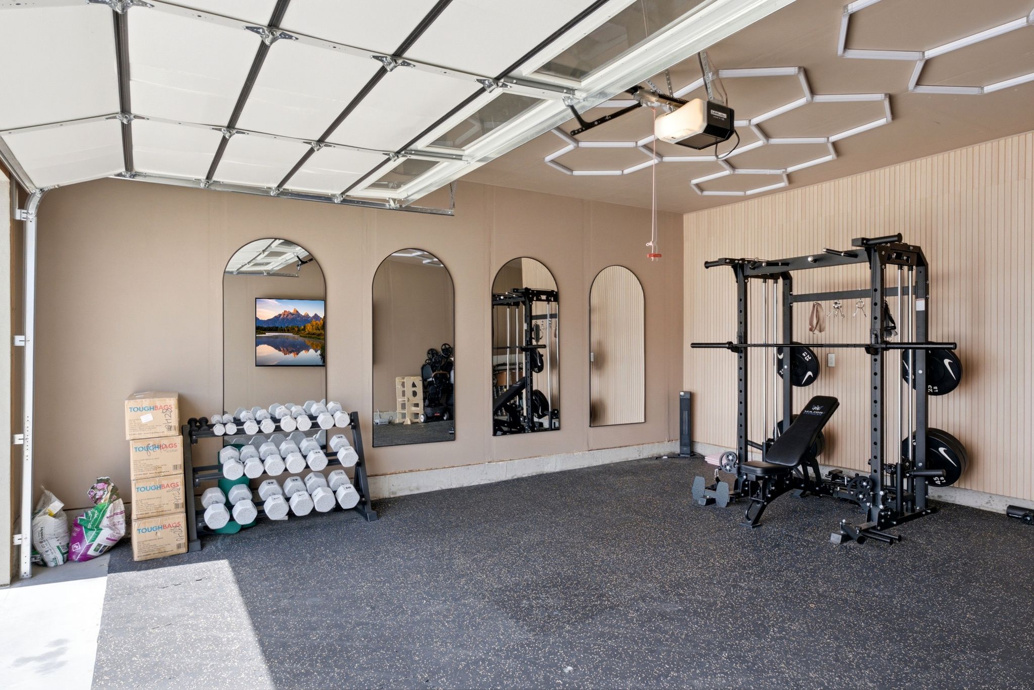 Dedicated fitness space featuring rubberized flooring and paneled accent wall