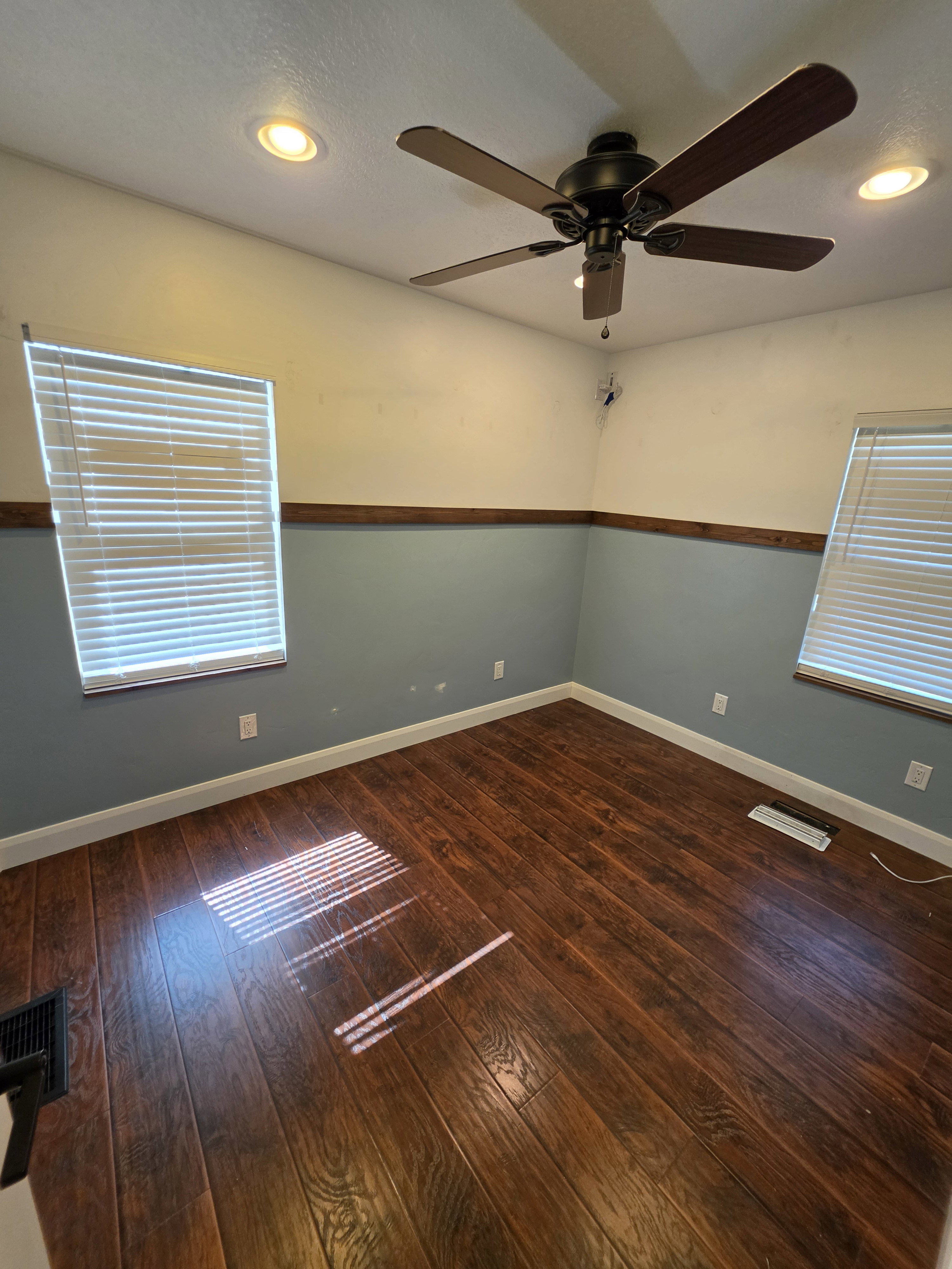 Room featuring wood-finish flooring, two windows with blinds, recessed lighting, and a ceiling fan