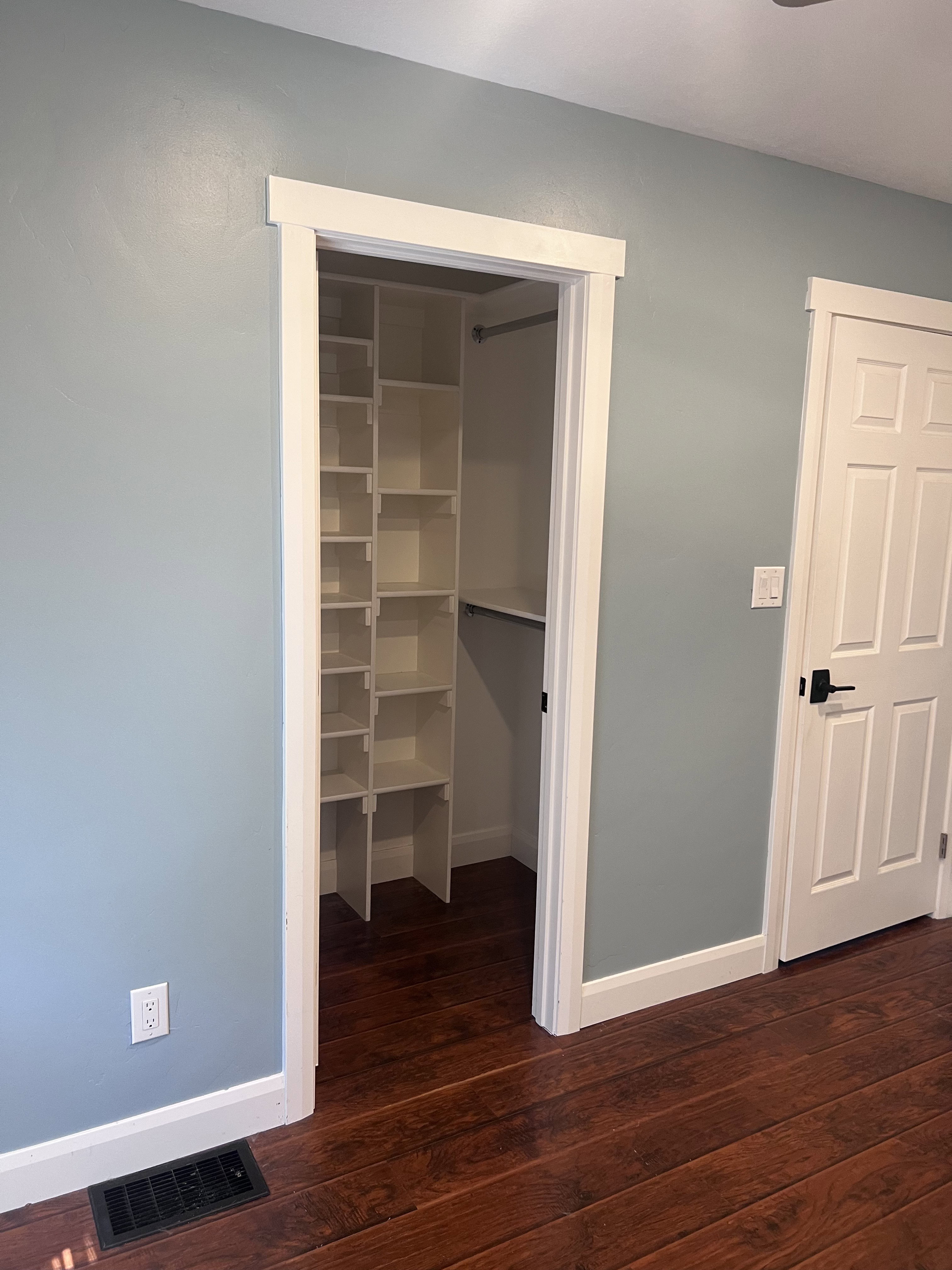 Walk-in closet featuring extensive built-in shelving and hanging rod