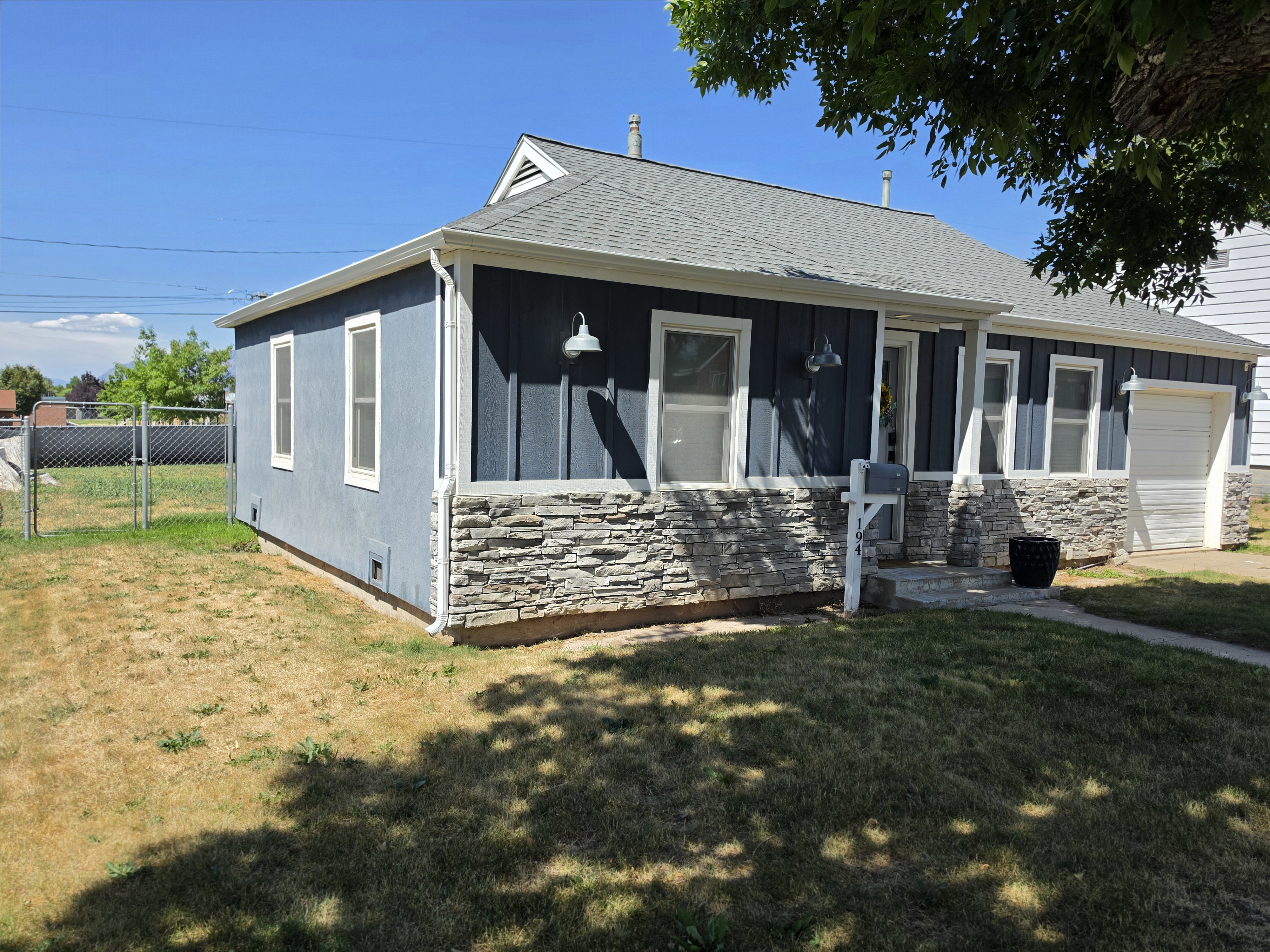 Front exterior featuring board and batten siding with a stone façade accent