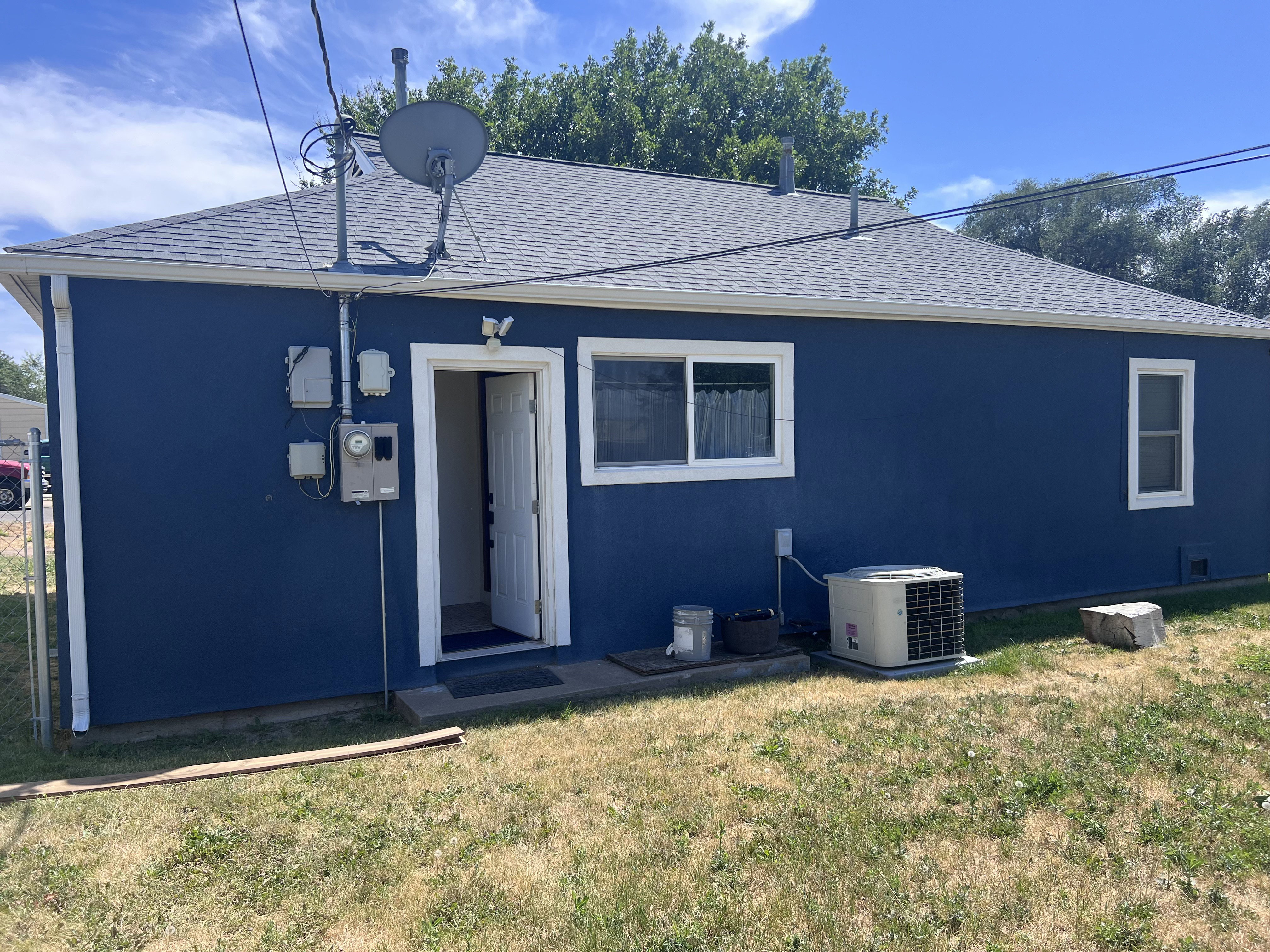 Deep blue exterior with white trim windows and entry door