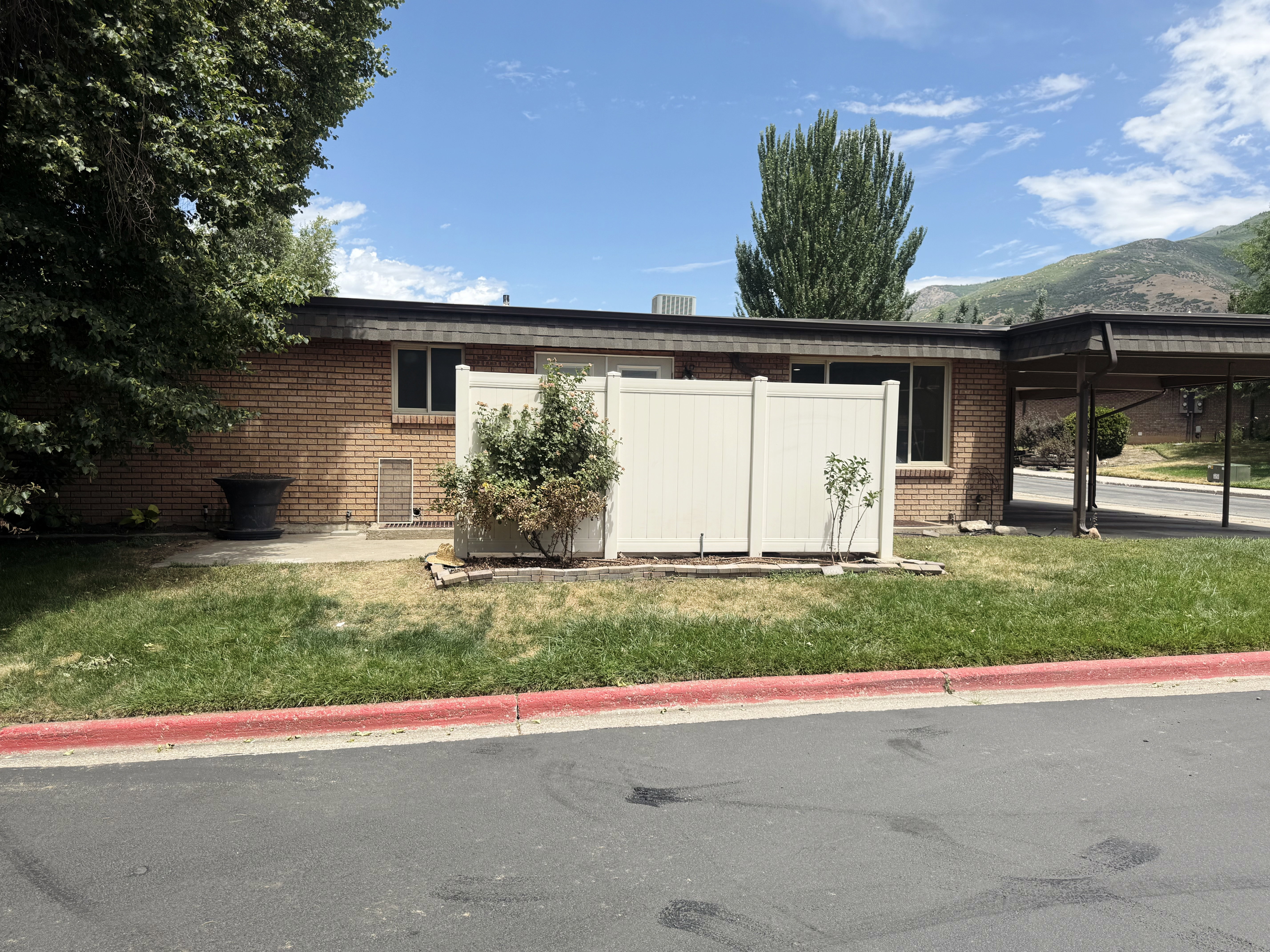 Brick exterior with multiple windows and a carport
