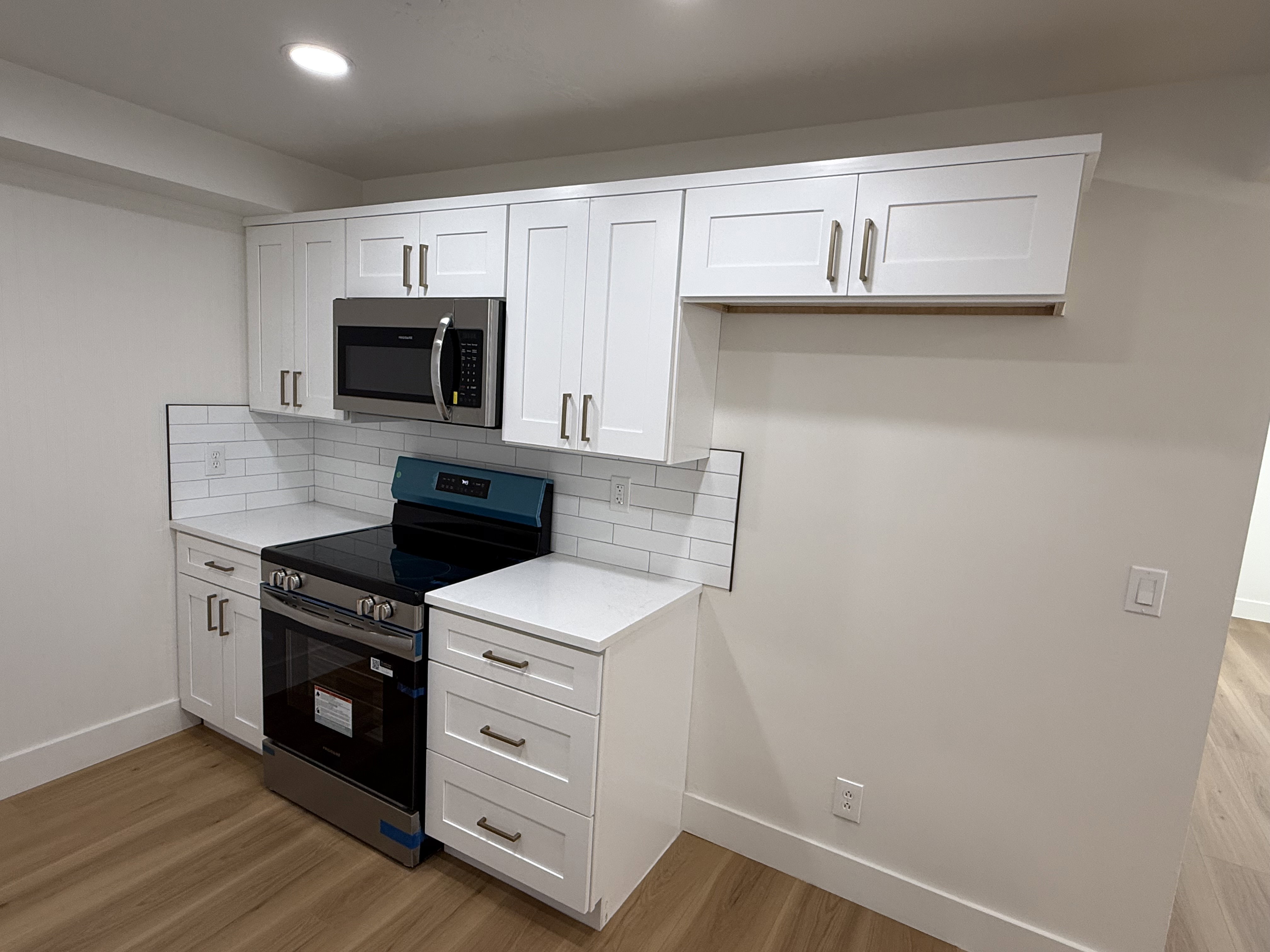 Kitchen area featuring white shaker-style cabinetry, a stainless steel range, and an over-the-range microwave