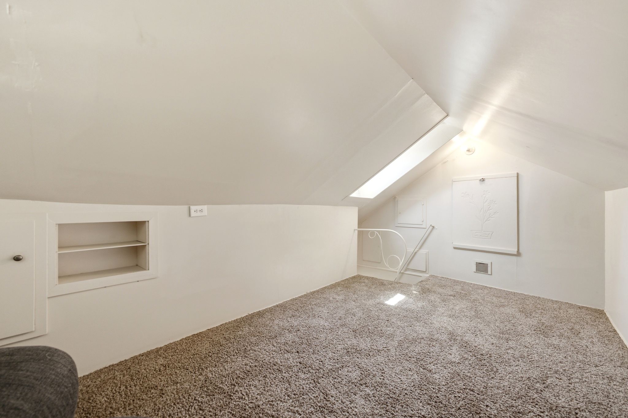 Carpeted room with sloped ceilings