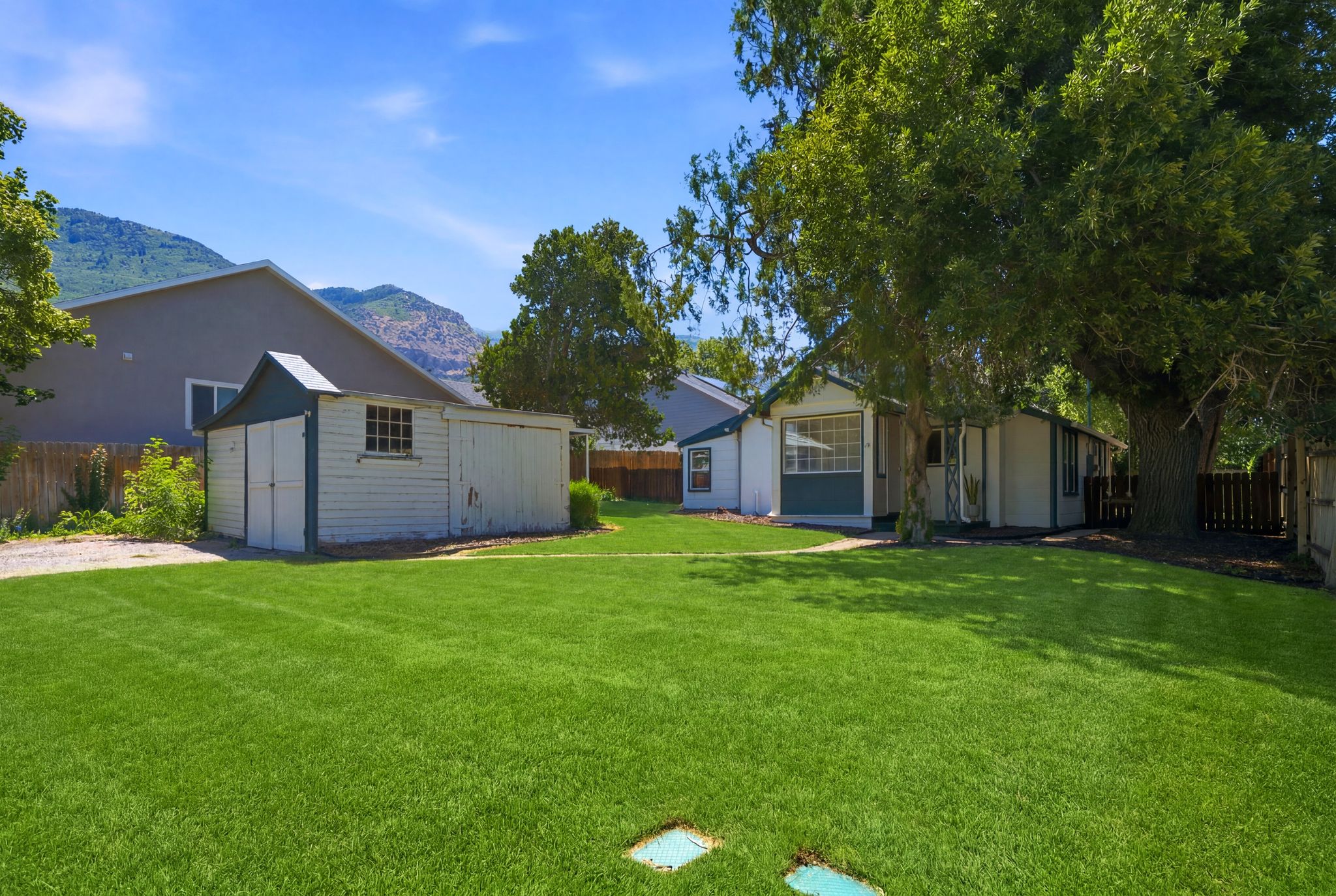 Expansive lawn with a detached storage shed and mature trees
