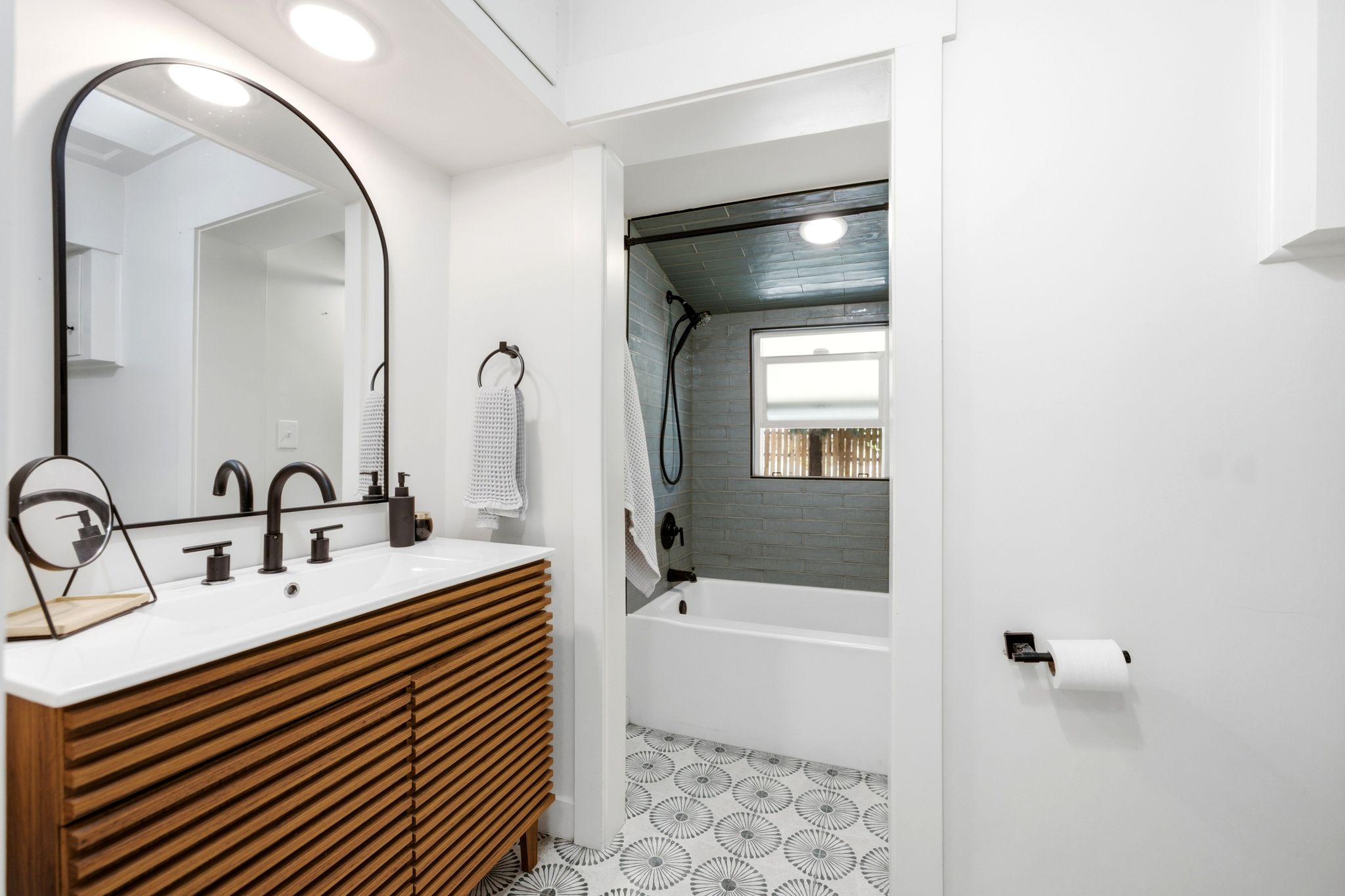 Bathroom featuring a slatted wood-finish vanity with a white countertop and rectangular undermount sink