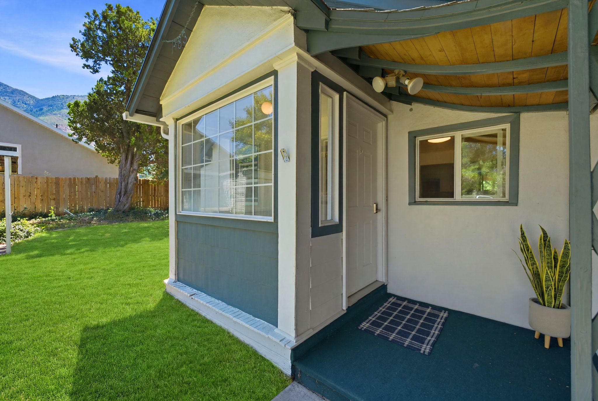 Covered front entrance with a paneled door and overhead lighting