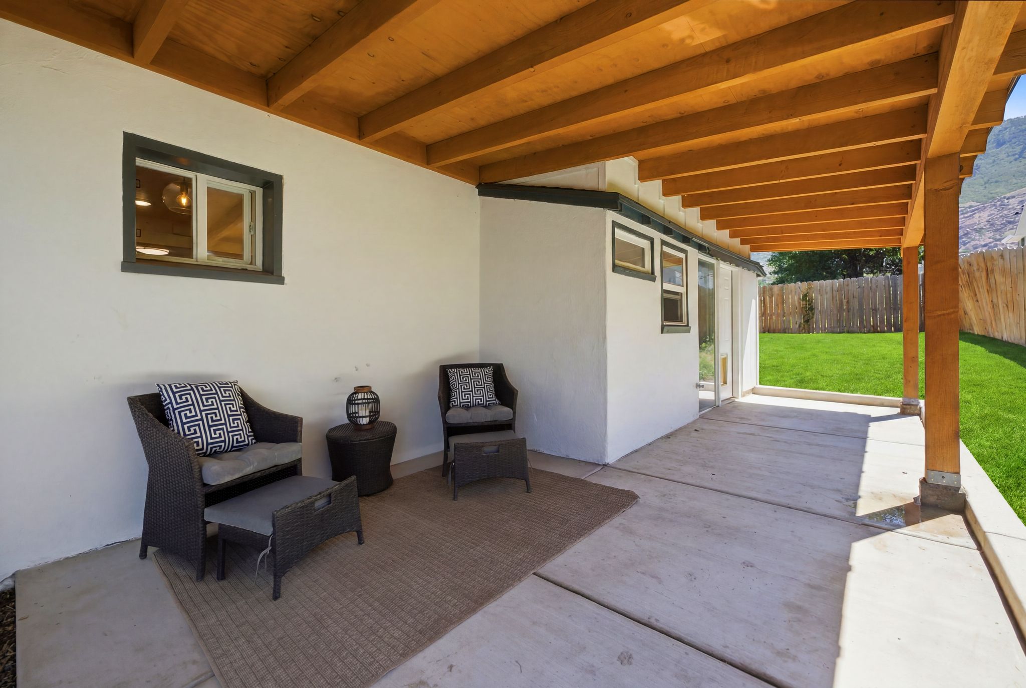 Expansive covered patio featuring a wood beam ceiling and concrete flooring